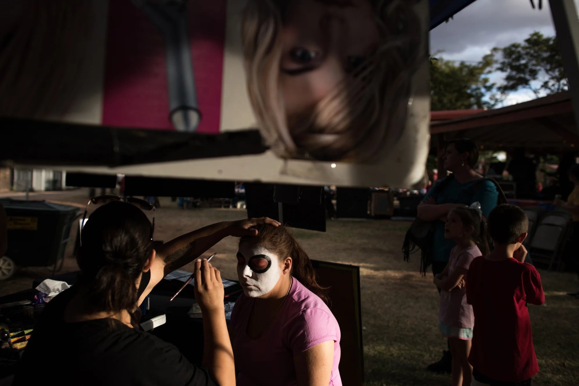 Delilah gets her face painted “Day of the Dead” style during a Catholic festival.