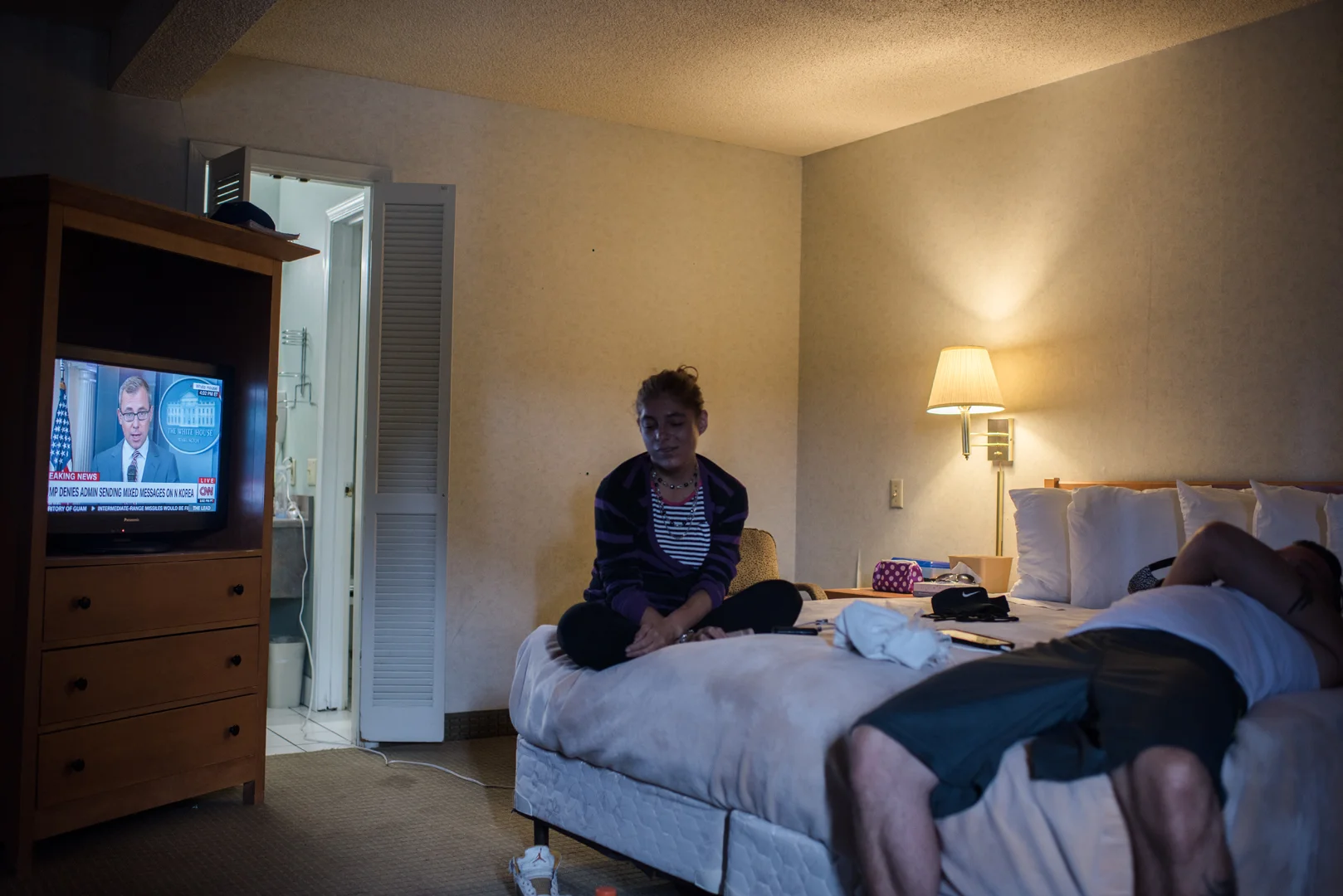 Delilah sits on the bed beside a man who calls himself KC who invited her to his motel room.