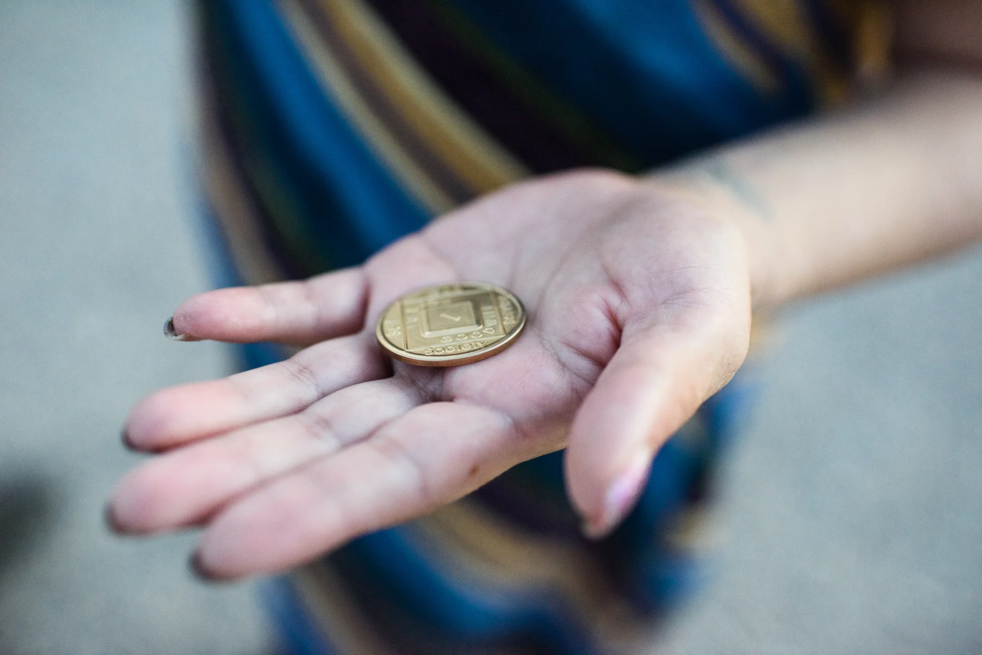 Delilah holds her 1-year sobriety chip in the palm of her hand.