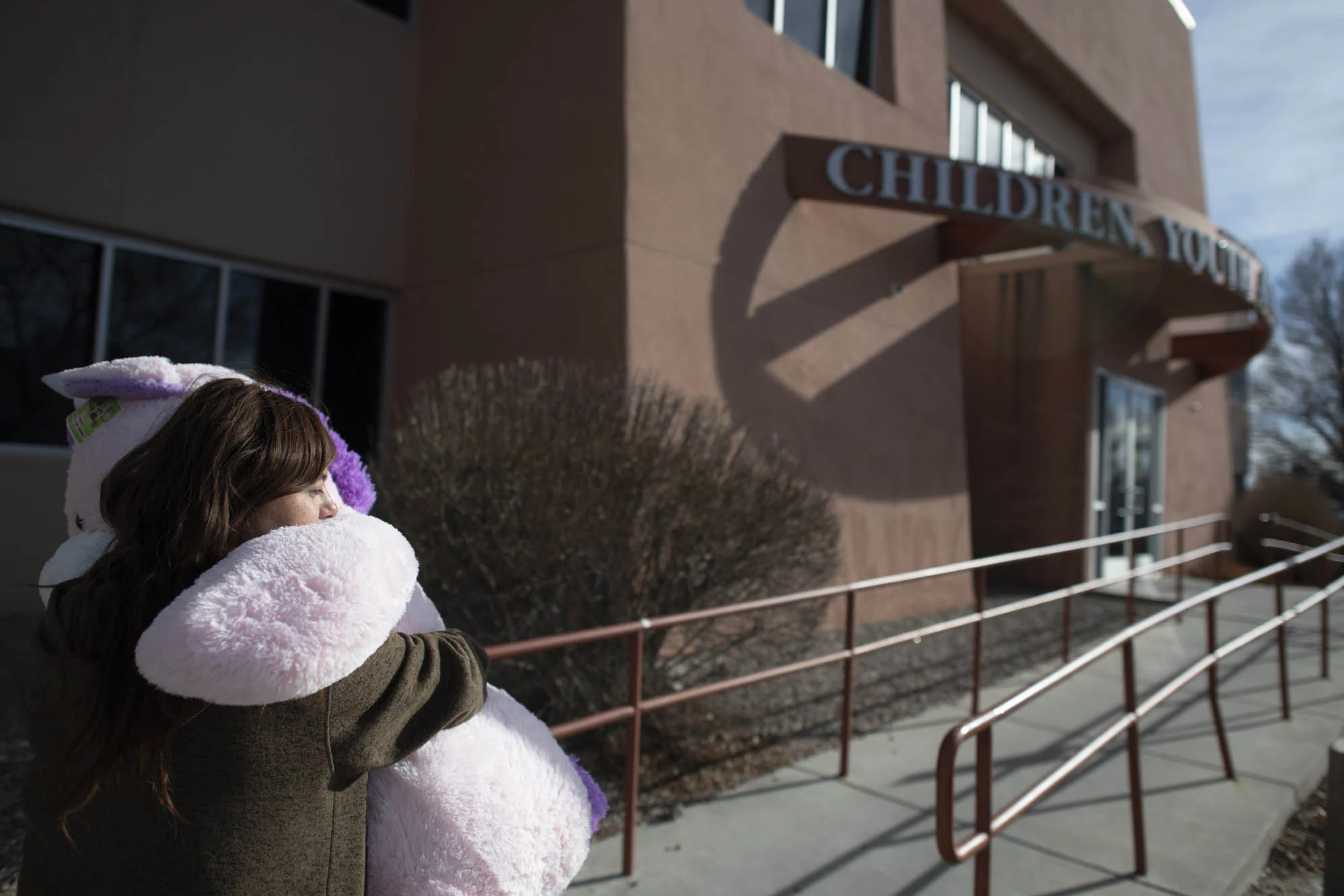 Delilah carries a stuffed animal she bought Esperanza for Christmas, as she walks towards the CYFD building for her visit.