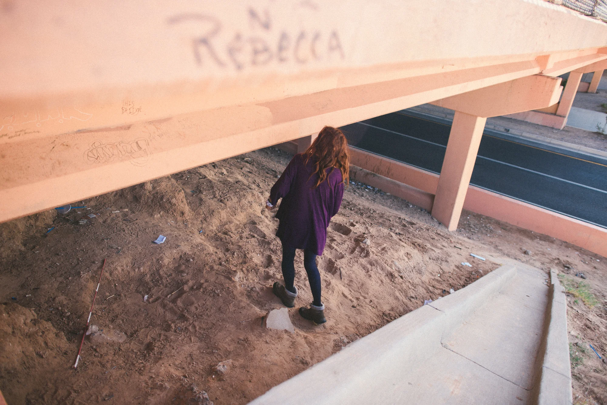 Delilah walks underneath the bridge where she sleeps with CJ.
