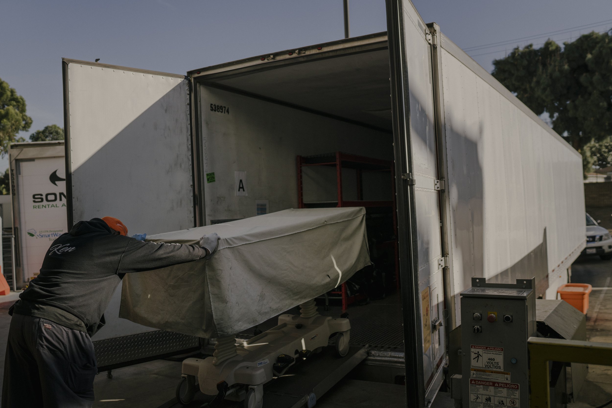  Kenneth Ludgood, a member of the transport team for five years, pushes a gurney that carries the body of Gabriel Flores into the temporary morgue. 