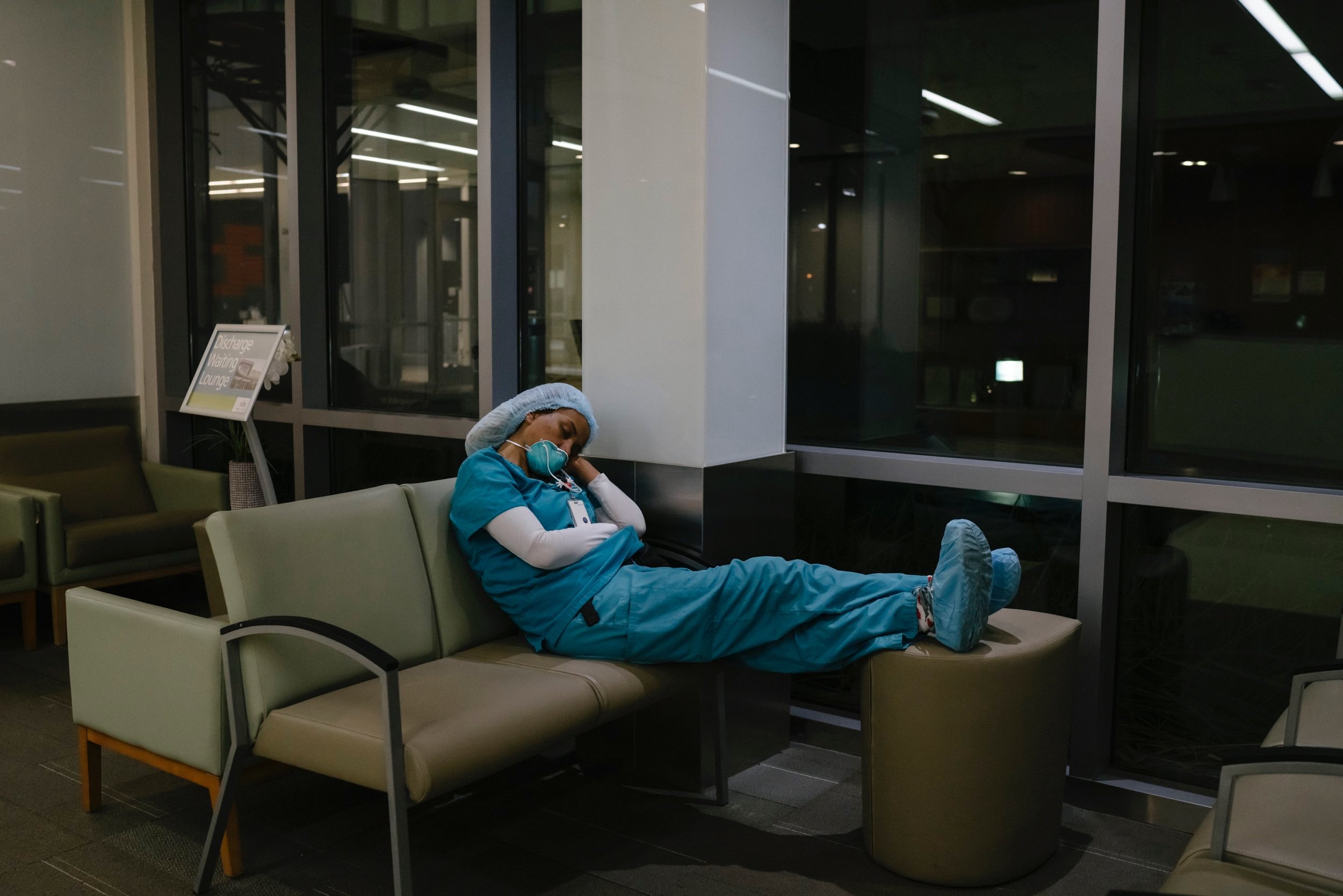  A healthcare workers sleeps during a break at 2 AM in the lobby. 