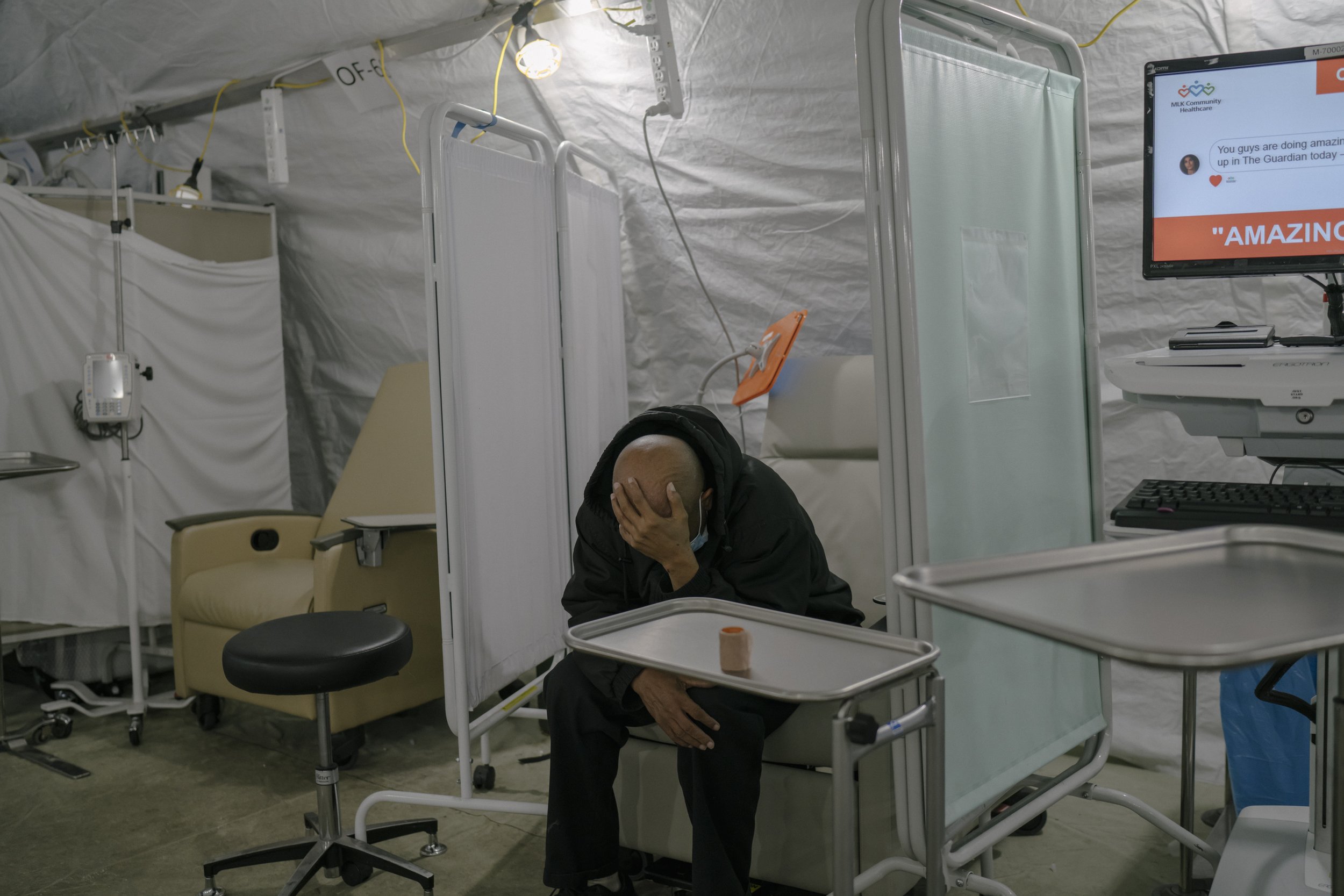  A man sits in the the triage tent for those with COVID-19 symptoms outside the Emergency Department. 