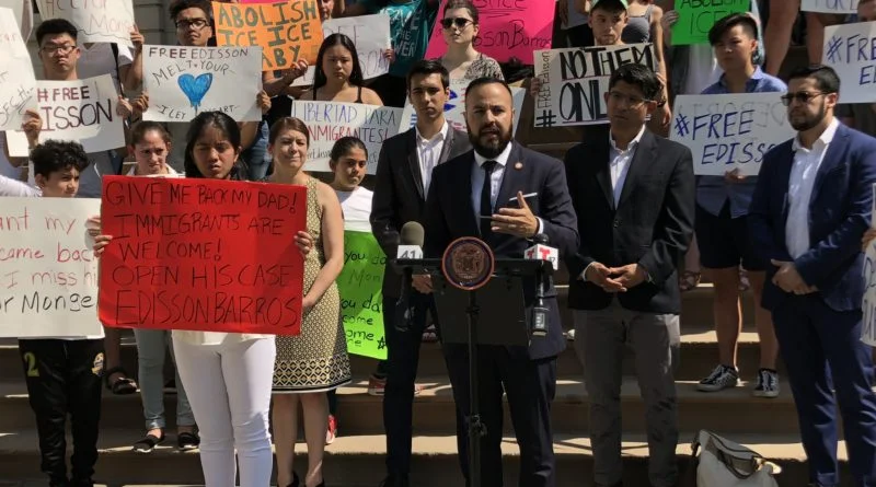 Barros’ daughter Eileen holds a sign that says “Give me back my dad” as she stands with Council Member Francisco Moya and demonstrators on the steps of City Hall Friday. Photo courtesy of Francisco Moya.