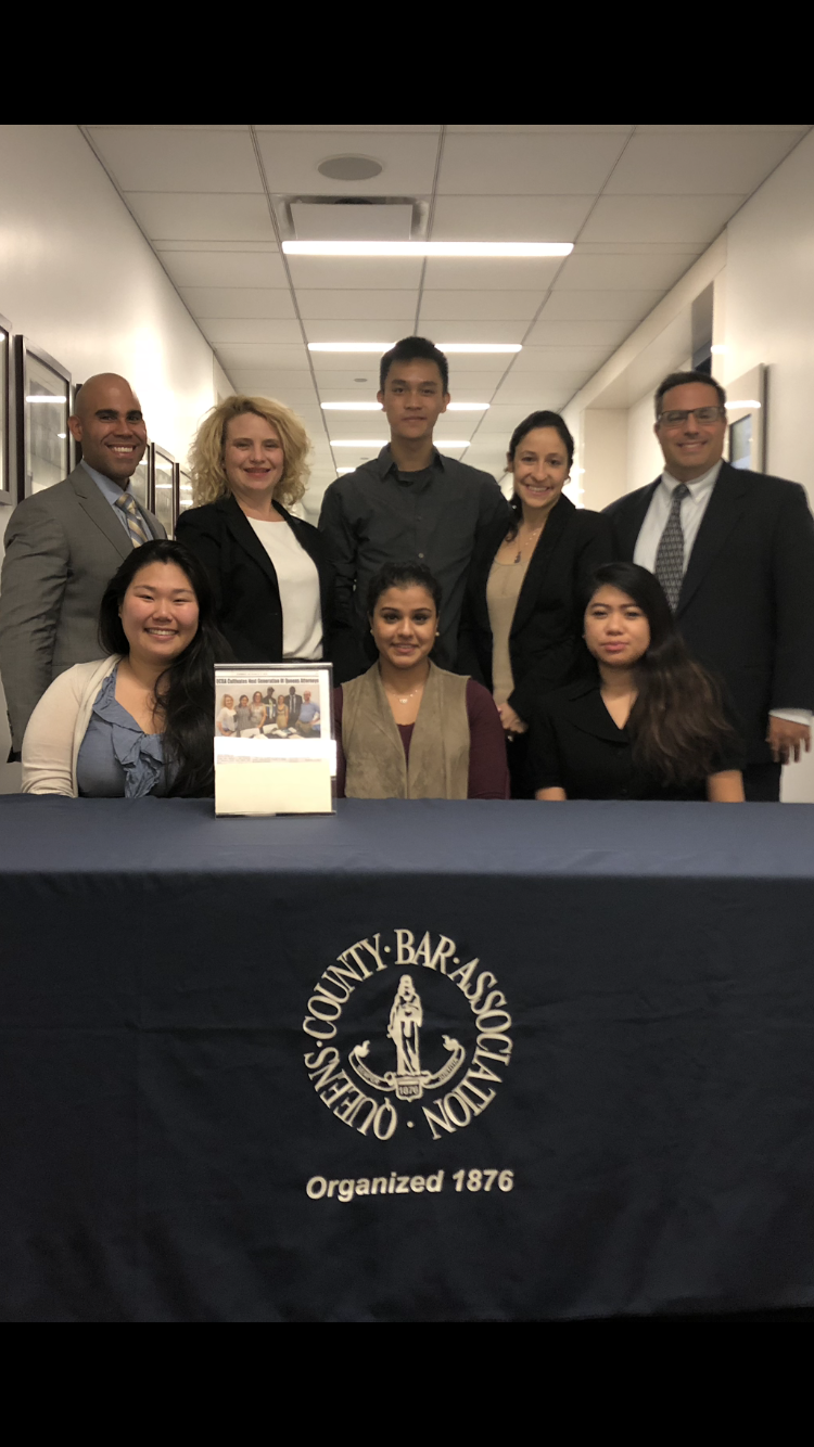 Seated Left to Right: Christina Lee, Asya Abad, Jeri Milan. Standing Left to Right: Joel Serrano, Marie-Eleana First, James Nguyen, Kristen Dubowski Barba, Frank Bruno, Jr. Photo courtesy of QCBA.