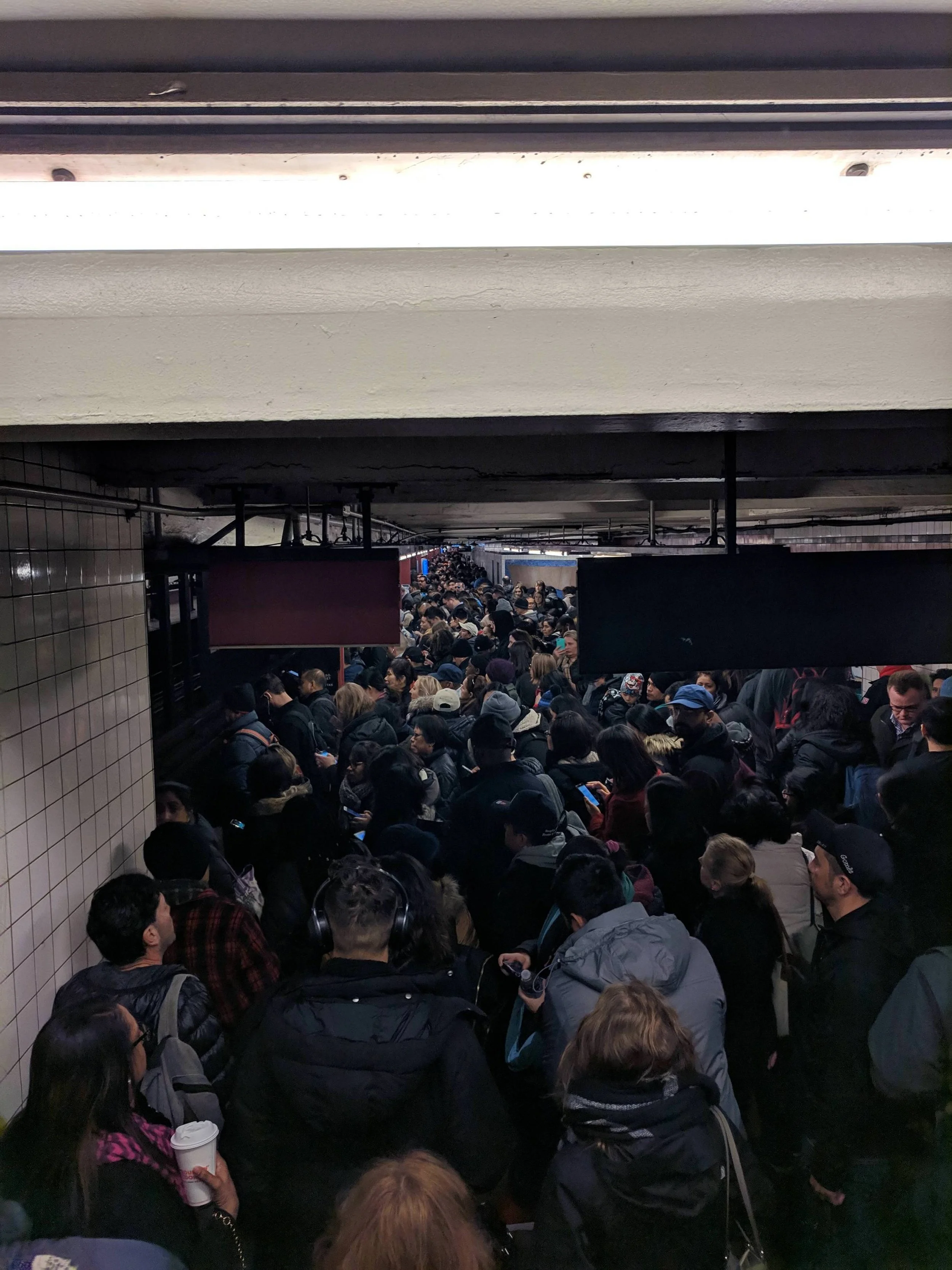 Commuters attempt to get to the E train platform at Court Square in Long Island City. Photos courtesy of Euoi.