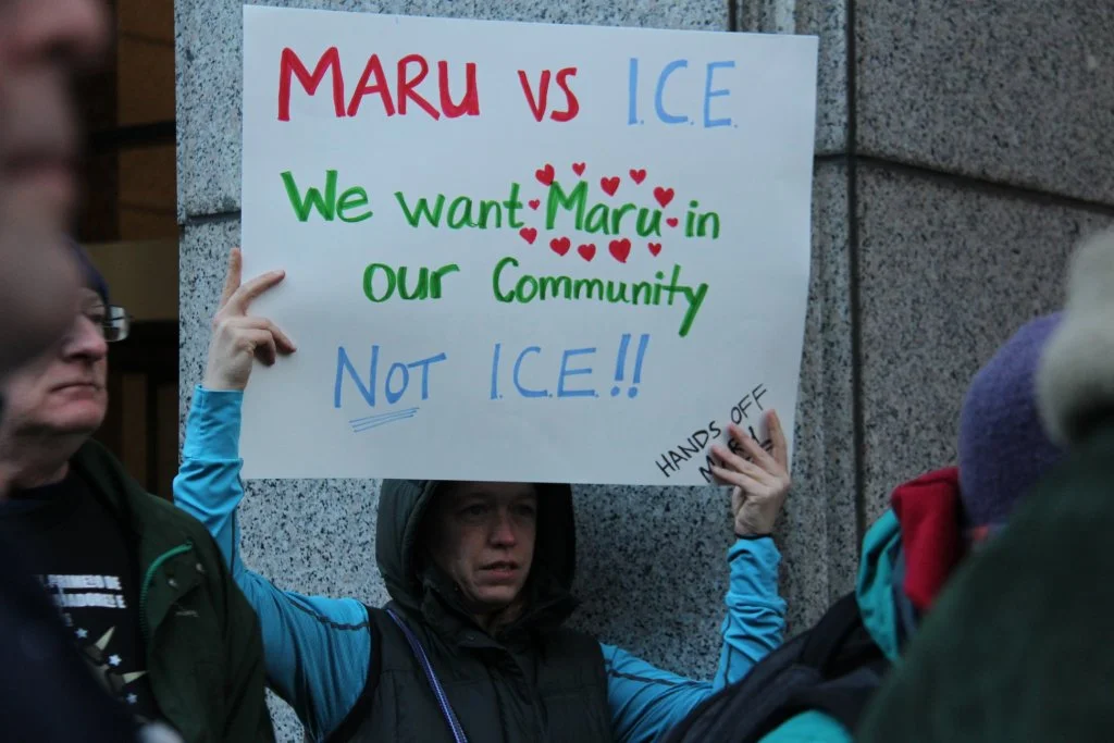 A demonstrator outside Immigration Court holds a sign in support of Maru Mora Villalpando. Photo via Law at the Margins courtesy of NWDC.