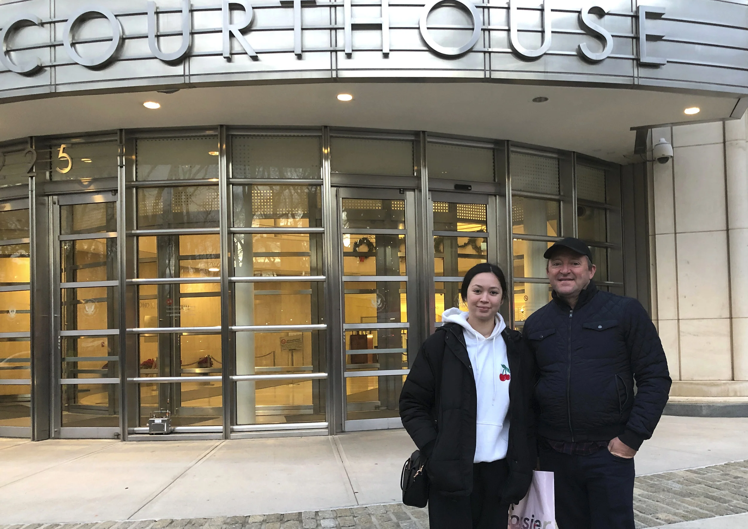 In this Dec. 3, 2018 photo, Australian tourists Wayne and Lydia stand in front of Brooklyn's federal courthouse in New York, where they were attending the trial of Mexican drug trafficker Joaquin "El Chapo" Guzman. Burg is a criminal lawyer in his home country and said he did not want to miss the chance to witness one day in the trial of "El Chapo." AP Photo/Claudia Torrens.