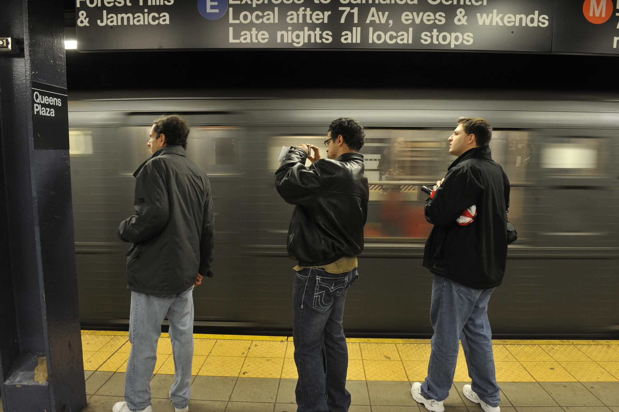 Commuters wait for a train at Queens Plaza. Photo via the MTA.