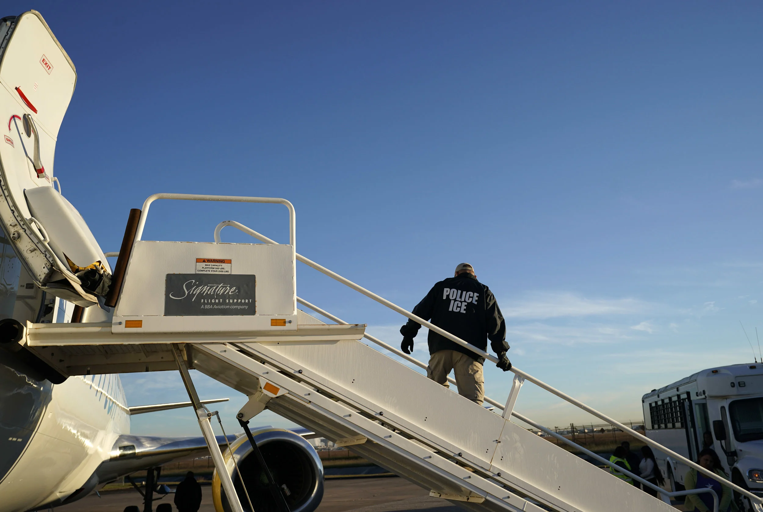An officer watches as immigrants who entered the United States illegally are deported on a flight to El Salvador by U.S. Immigration and Customs Enforcement. (AP Photo/David J. Phillip)