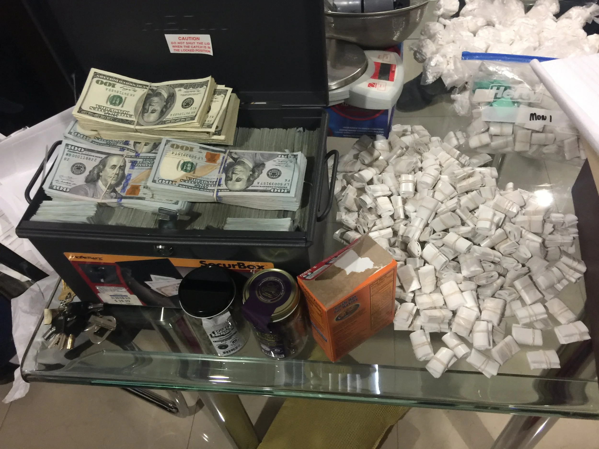 Cash and narcotics A pile of cash and narcotics allegedly siezed as part of a bust of a drug delivery service that prosecutors claim operated in numerous Southern Brooklyn neighborhoods. A total of 15 pounds of heroin and cocaine plus nearly $800,000 in cash was allegedly seized in one raid. Photo courtesy of the Office of the Special Narcotics Prosecutor.