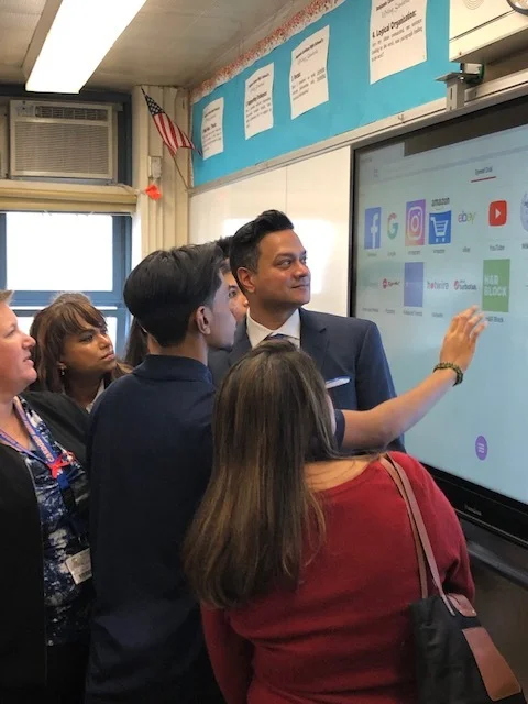 Subraj Foundation Director Tony Subraj looks on as students demonstrate the new Promethean board at Benjamin Cardozo High School.