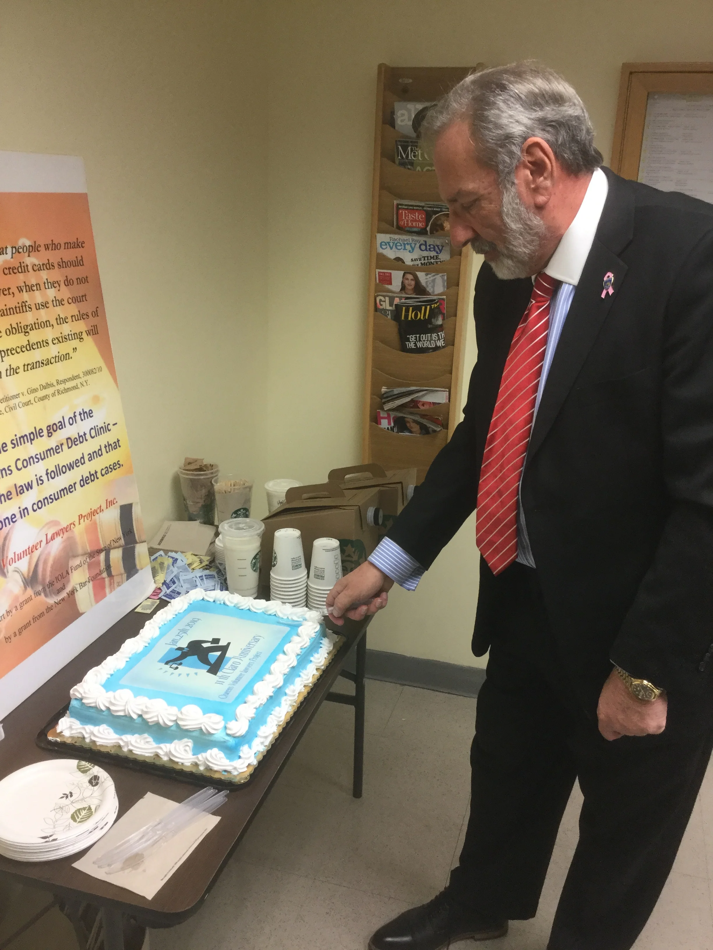QVLP Executive Director Mark Weliky cuts the CLARO birthday cake. Photo courtesy of the Queens Volunteer Lawyers Project.