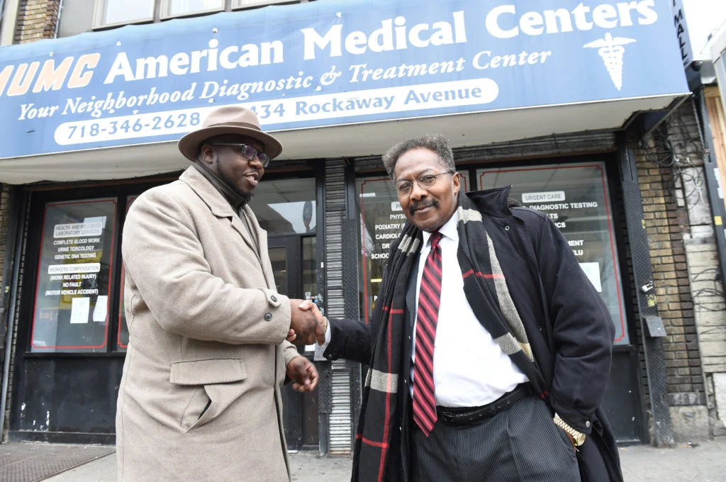 Rev. Kevin McCall (left) is joined by Tony Brown-Arkah, CEO of AMUMC American Medical Centers on Rockaway Avenue, as Brown donates space for feeding the homeless and federal workers. Eagle photo by Todd Maisel.