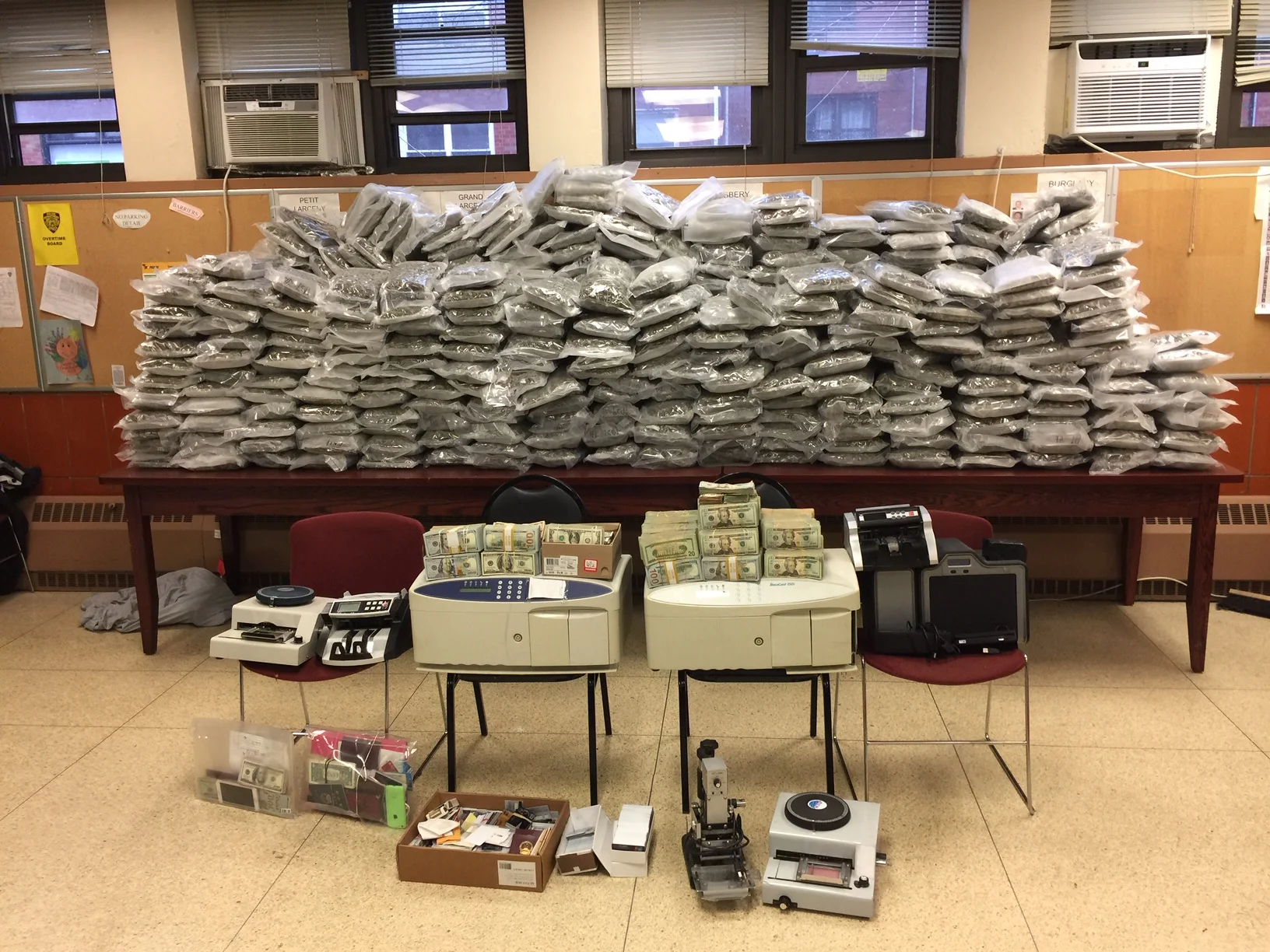 Police recovered $600,000 in cash and 480 one-pound packets of marijuana from a home in Flushing, where three defendants allegedly made counterfeit credit cards. Photo courtesy of the Queens DA’s Office.