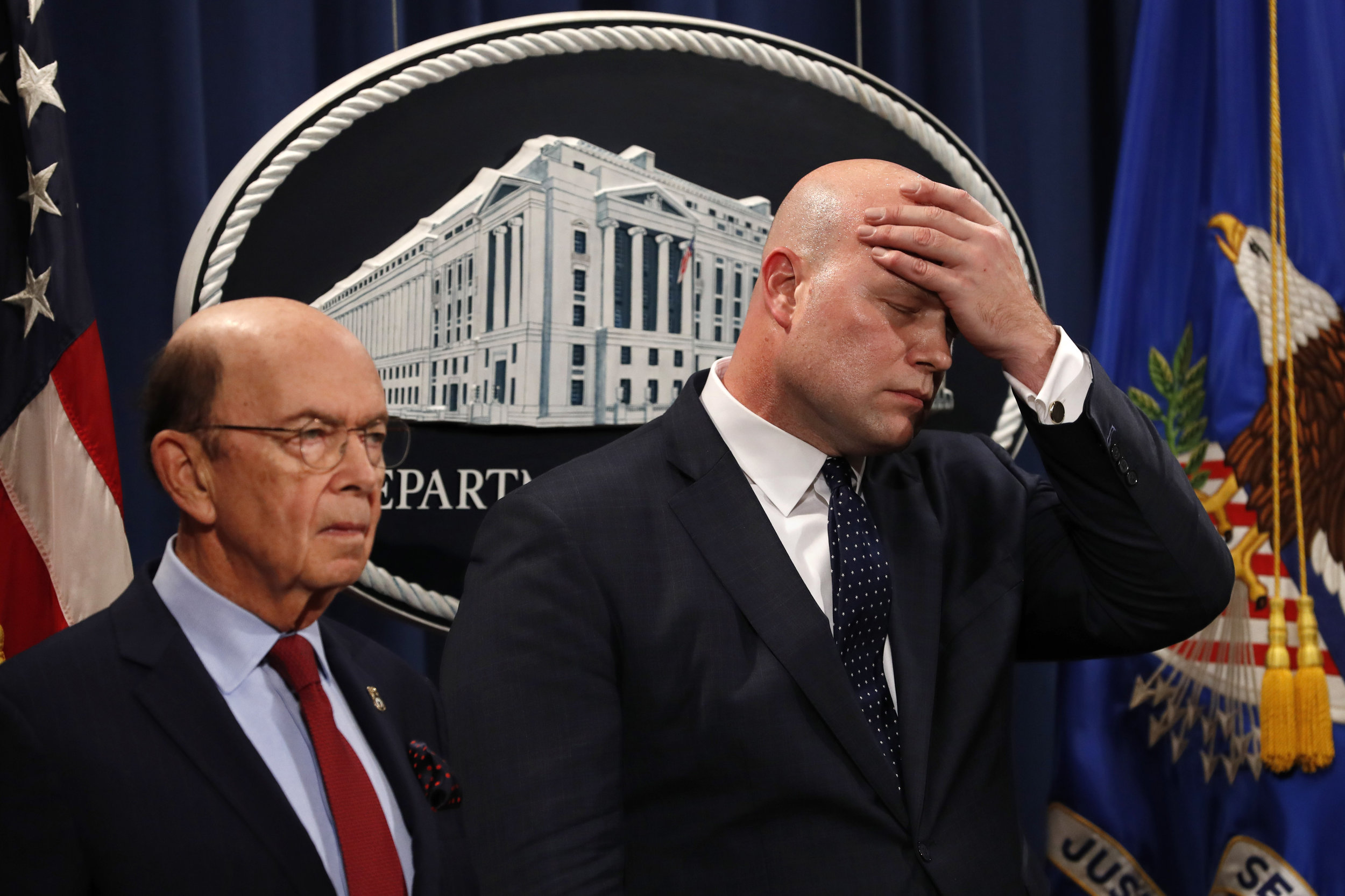 Acting Attorney General Matt Whitaker (right) wipes his brow Monday after announcing an indictment on violations including bank and wire fraud of Chinese telecommunications companies including Huawei at the Justice Department in Washington. At left is Commerce Secretary Wilbur Ross. AP Photo/Jacquelyn Martin.