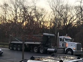 Trucks loaded with excavated dirt travel along Underhill Avenue in Flushing.