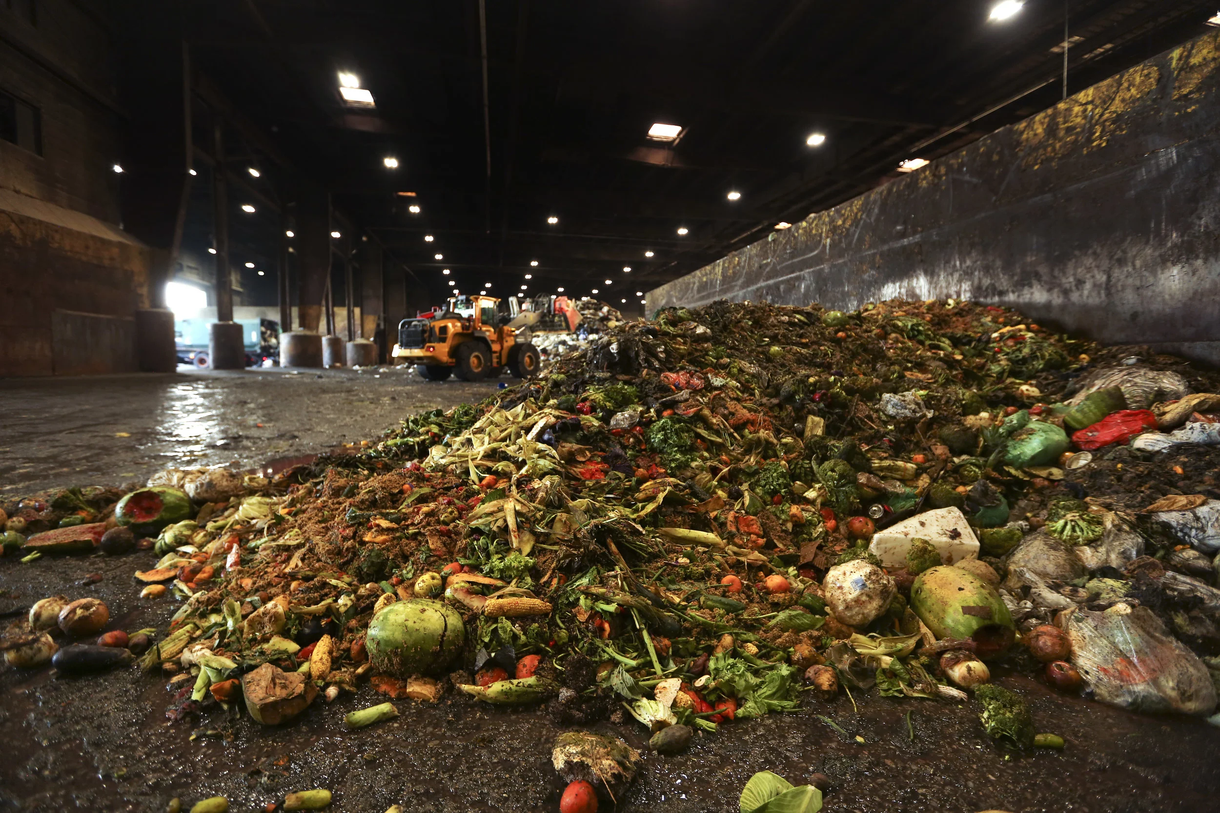 In this Aug. 29 photo, at the Waste Management facility in North Brooklyn, tons of leftover food sits piled up before being processed into biogas. A new report shows how getting more of the city’s organic waste into compost facilities and biogas plants would make a large financial difference. AP Photo/Stephen Groves.