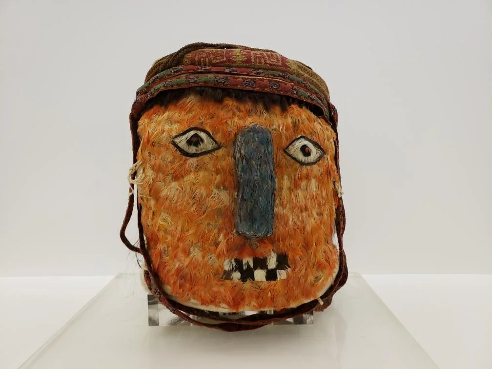 Feathered Mummy Bundle Mask, 600-1000, Peru. Feathers, undyed natural fiber and hair. Photo courtesy of Queens College.