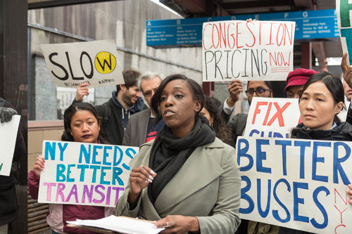Natasha Saunders of Riders Alliance speaks to commuters and advocates at a March congestion pricing rally outside of the Jamaica Center subway station, a hub for Queens buses. Eagle file photo by Jonathan Sperling.
