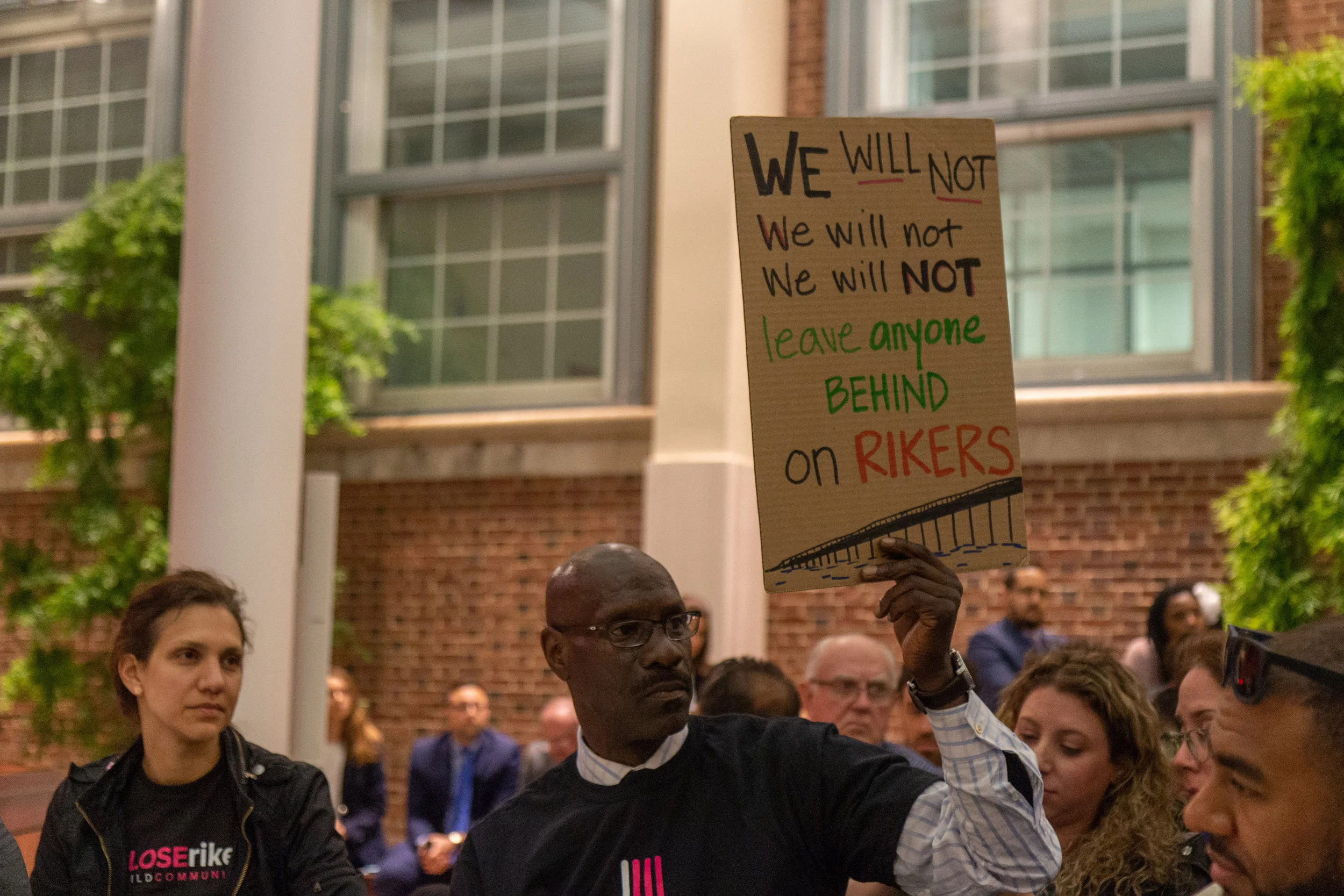 A member of #CLOSErikers holds a sign supporting the closure of Rikers Island jails.