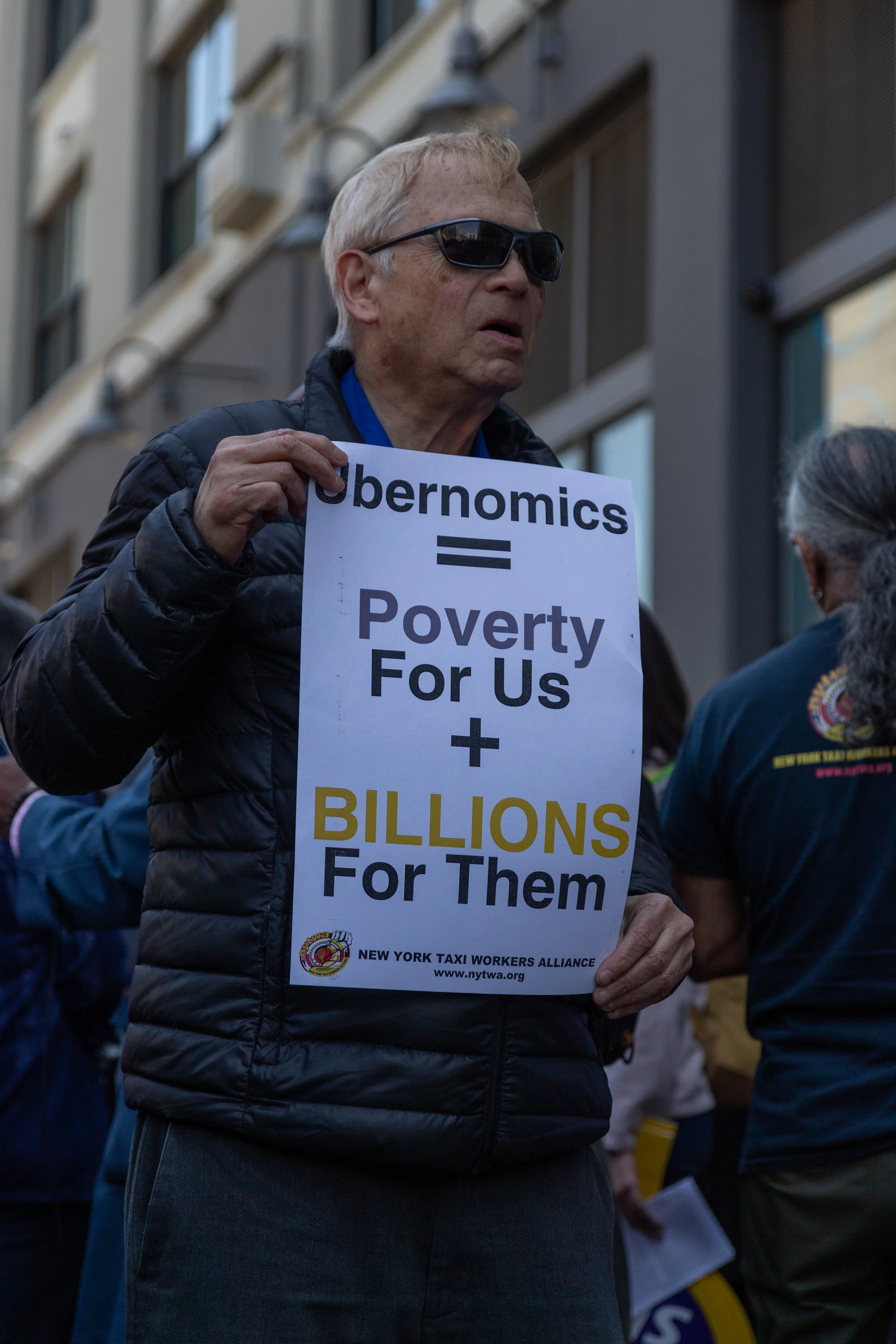 A demonstrator holds a sign at the rally criticizing Uber.