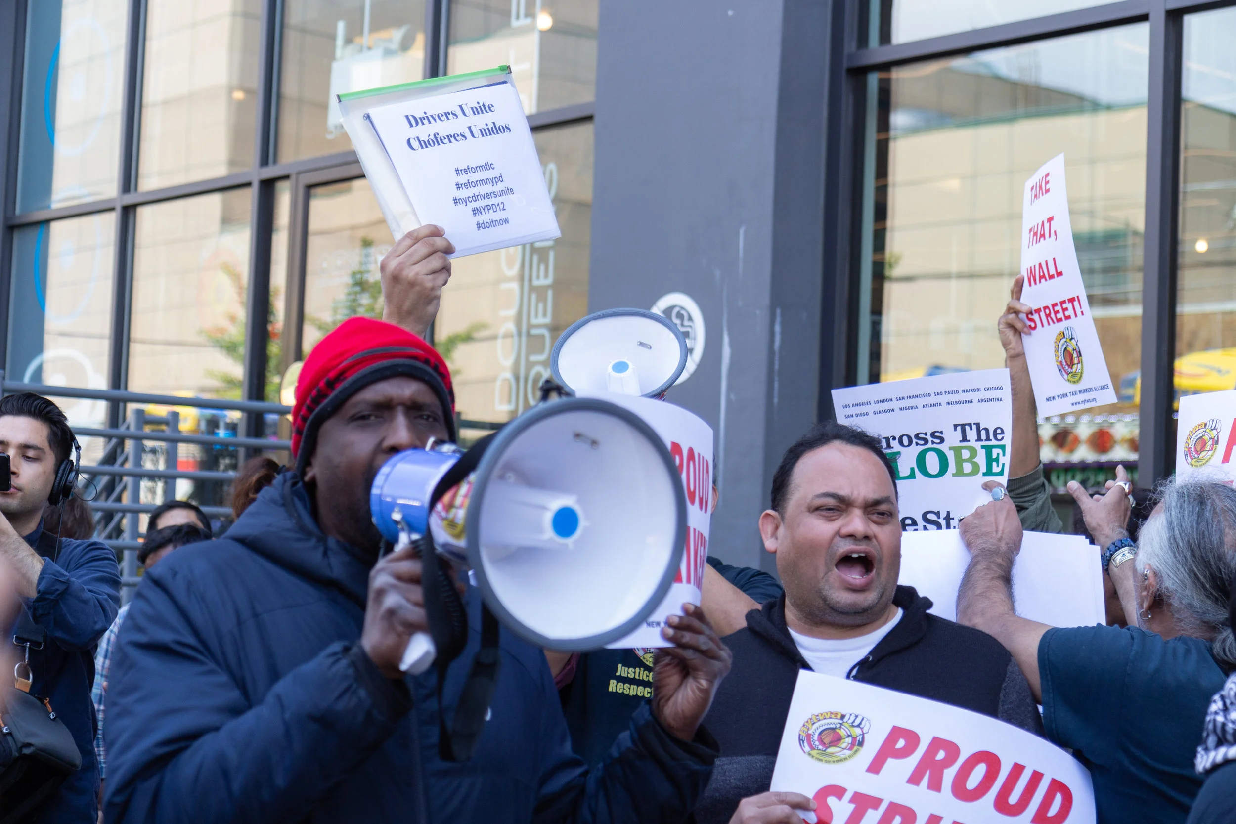 An app driver speaks into a megaphone at the rally.