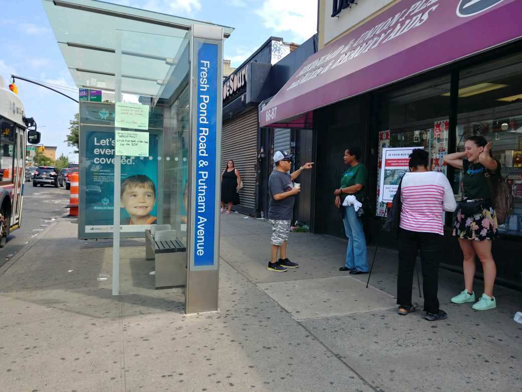 A member of Riders Alliance speaks to a resident in Ridgewood over the weekend about the proposed Fresh Pond Road bus lane. Photo courtesy of Riders Alliance.