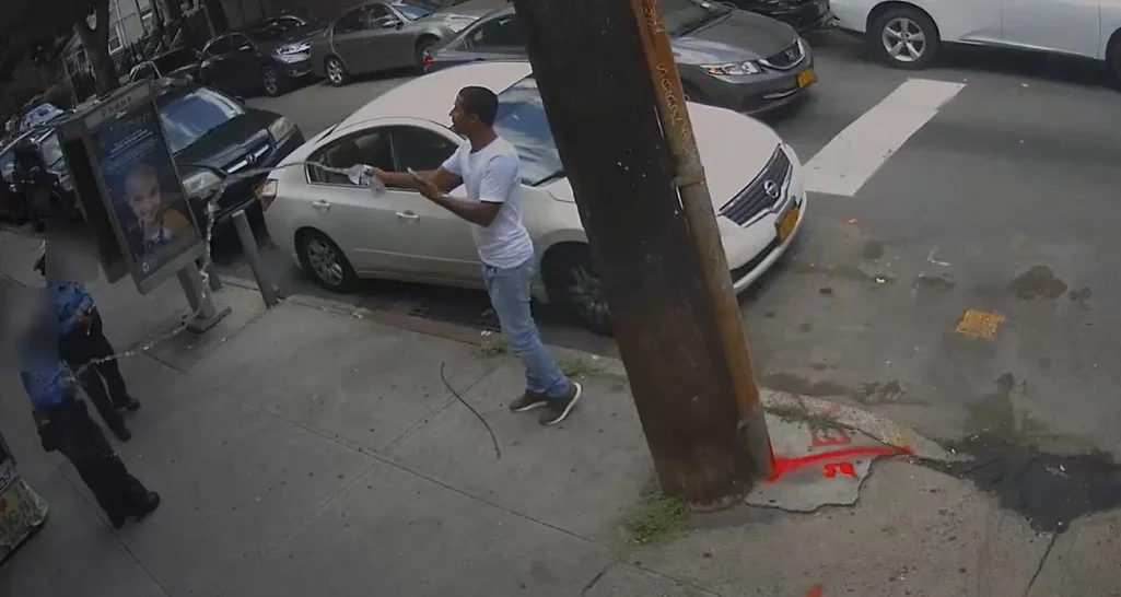 The agents were standing near Jamaica Avenue and 86th Street on July 24 when the man walked over and tossed the water on them. Screenshot courtesy of NYPD video.