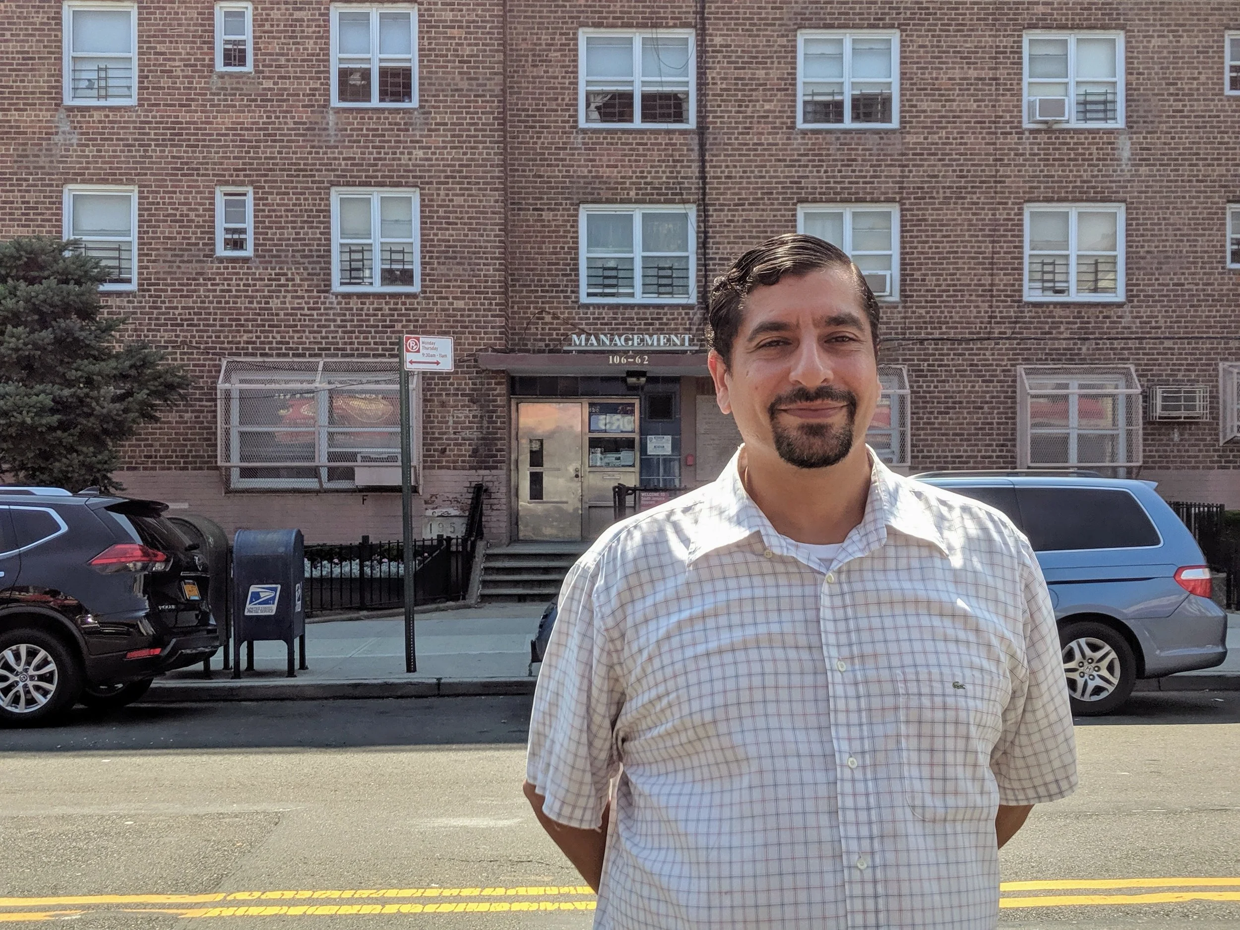 South Jamaica Houses Resident Council President Manny Martinez stands in front of the development’s community center. Eagle file photo by Phineas Rueckert.