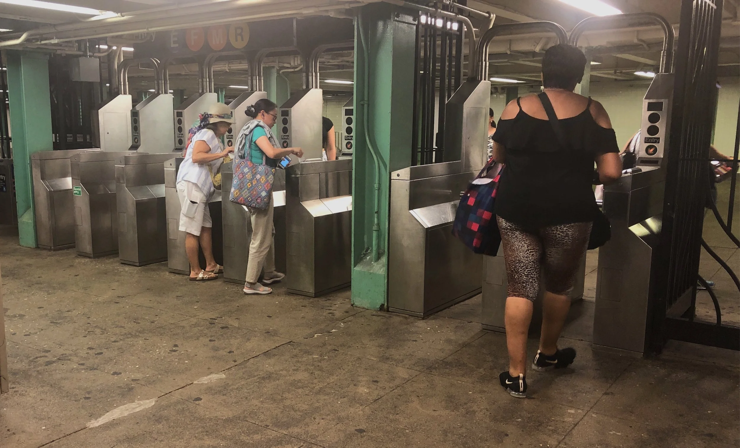 People swipe through the turnstile at the 71st Avenue station in Forest Hills. Eagle Photo by Rachel Vick.