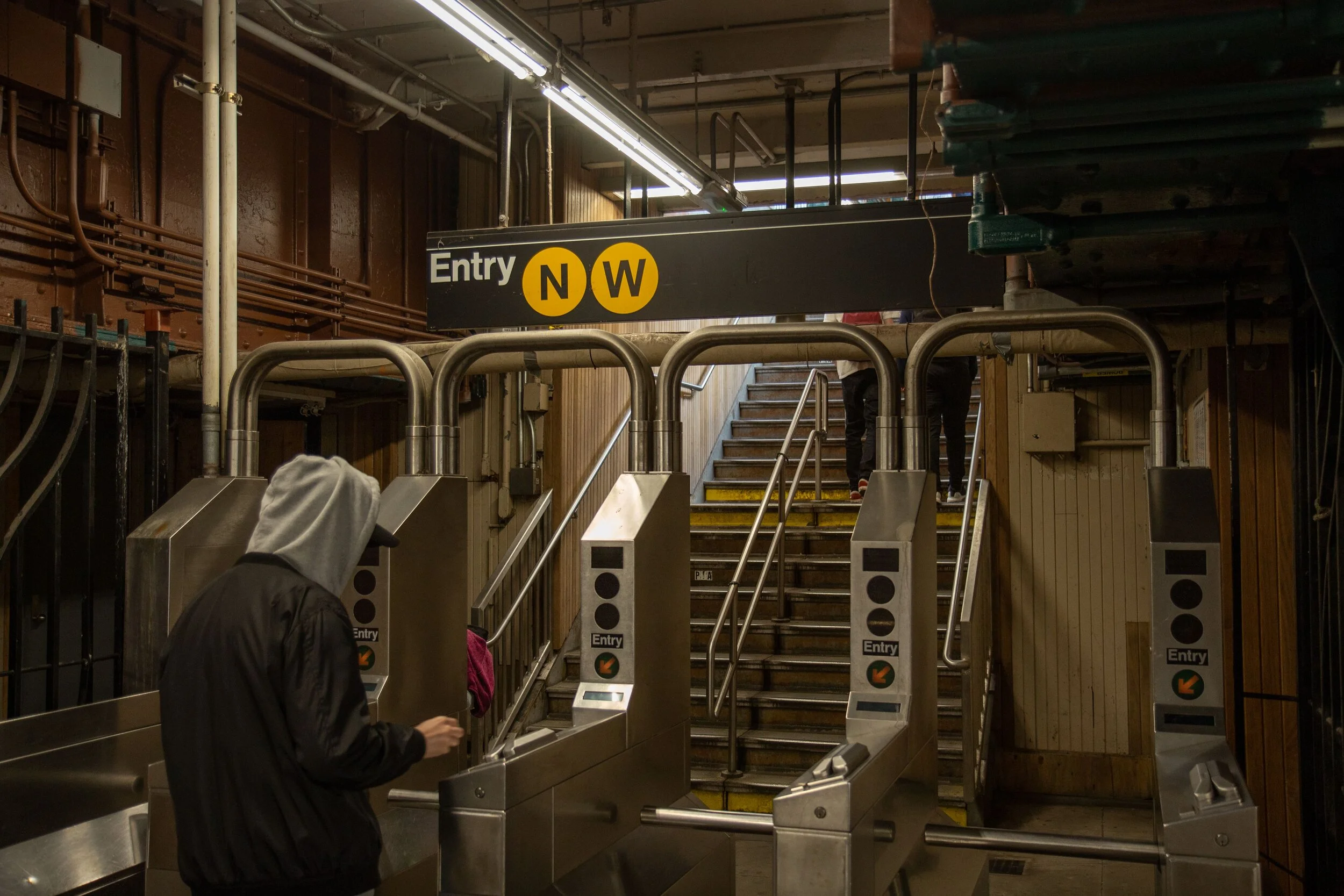 A man swipes through the turnstile at the Ditmars Boulevard Station in Astoria. Eagle file photo by Jonathan Sperling