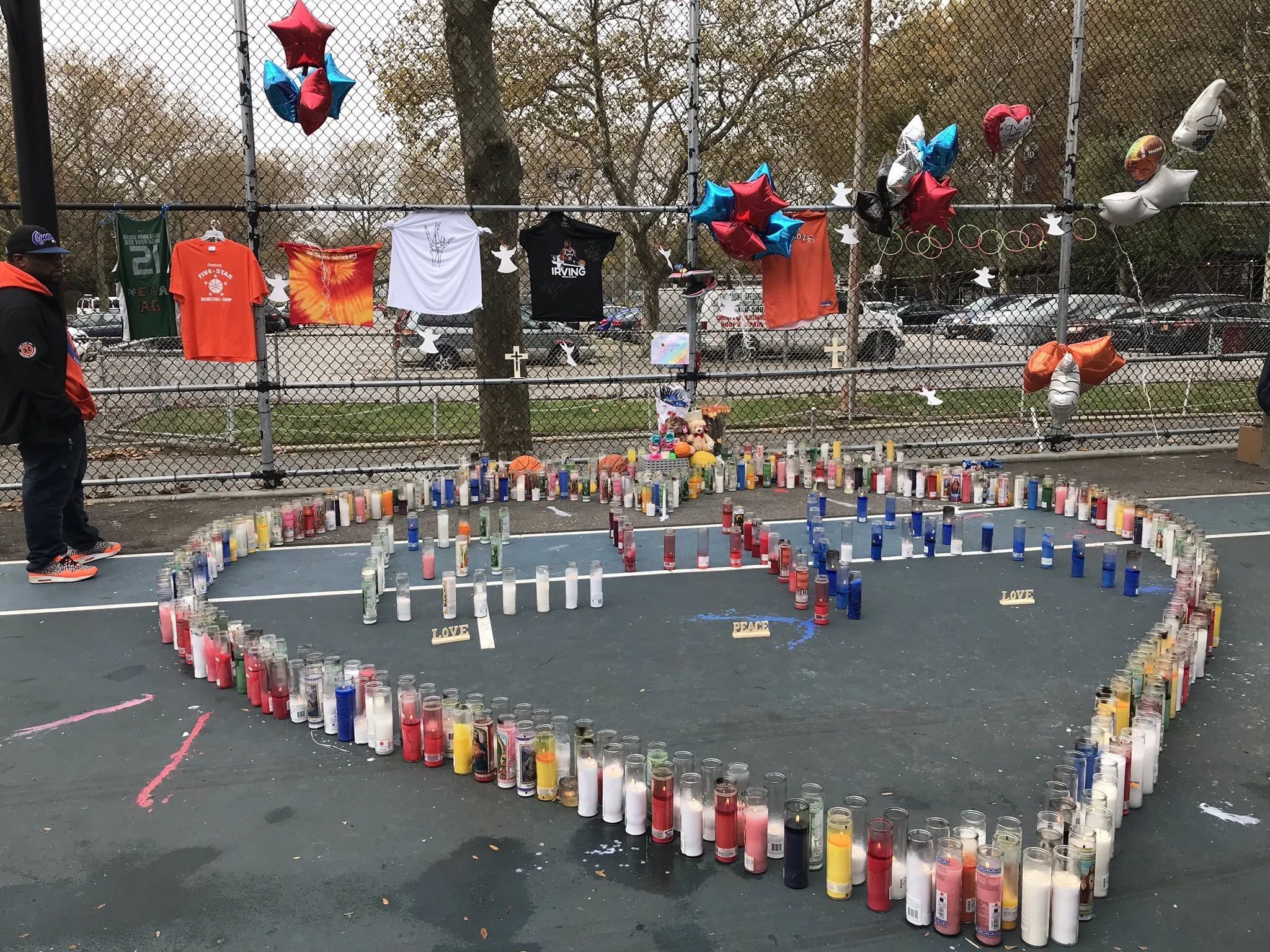 Votive candles arranged in a heart covered a piece of the basketball court where 14-year-old Amir Griffin was shot and killed on Saturday.