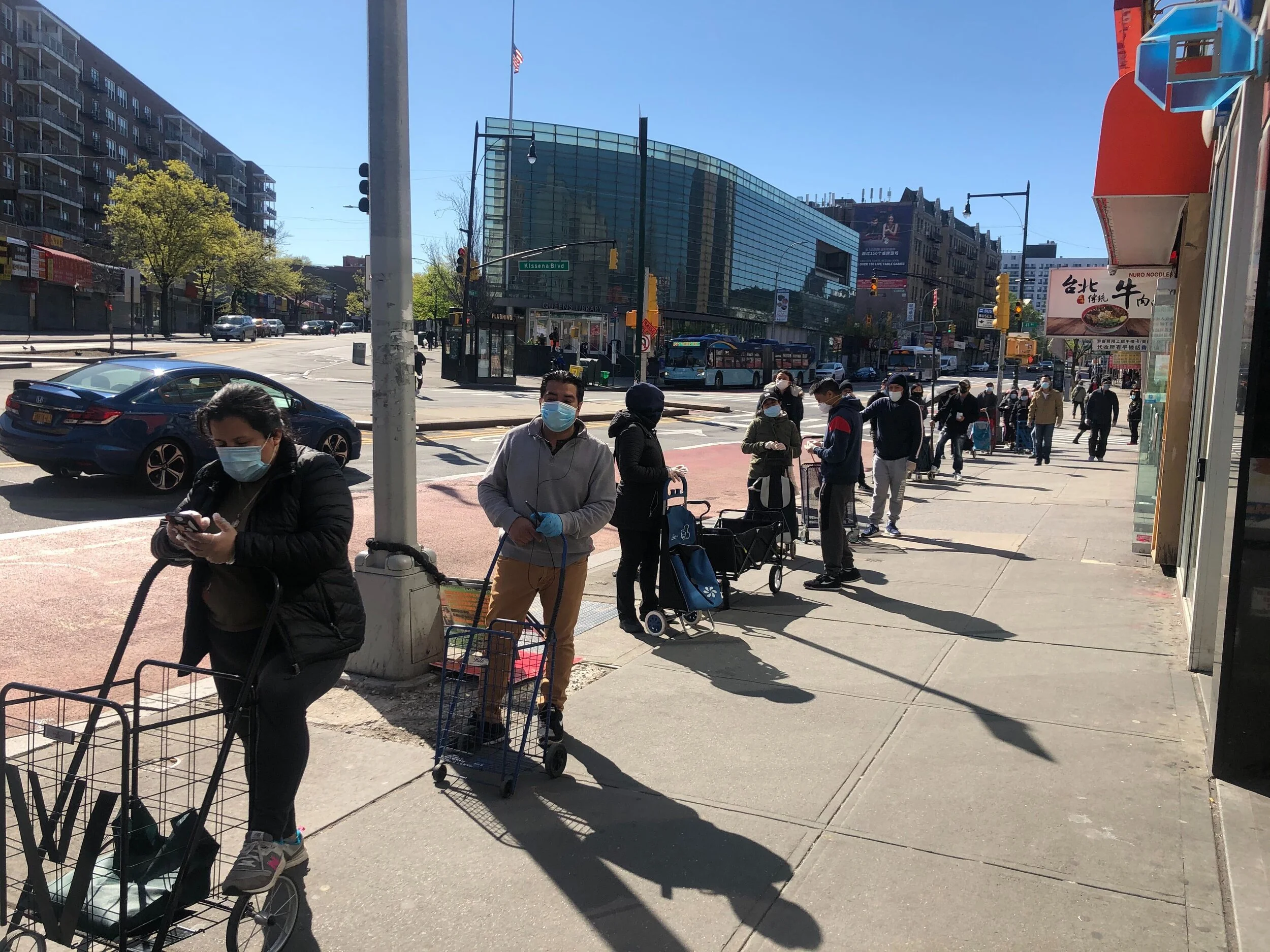 Flushing residents wait in a blocks-long line for supplies from a local food pantry. Photo courtesy of FADA