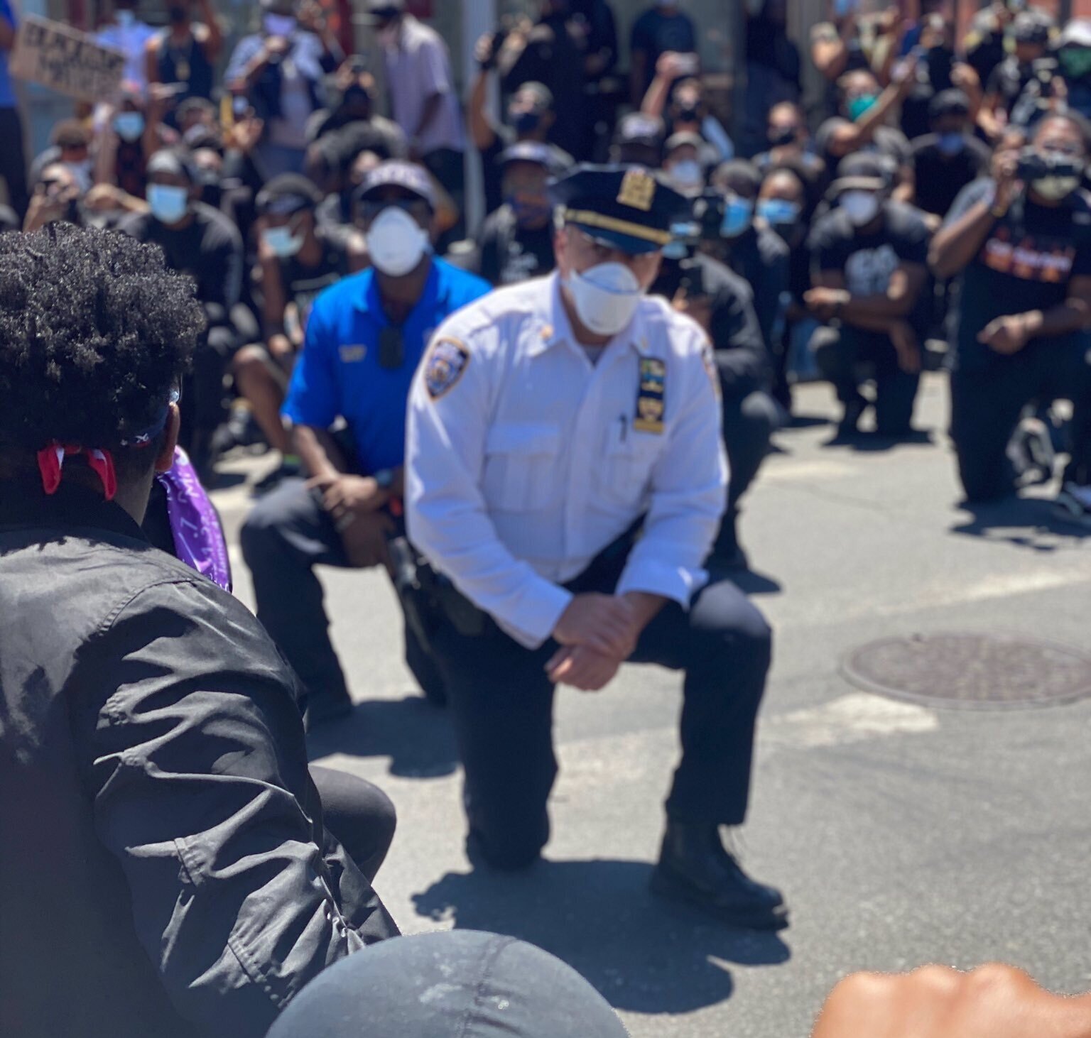NYPD officers kneel in solidarity with Jamaica demonstrators protesting racist police violence