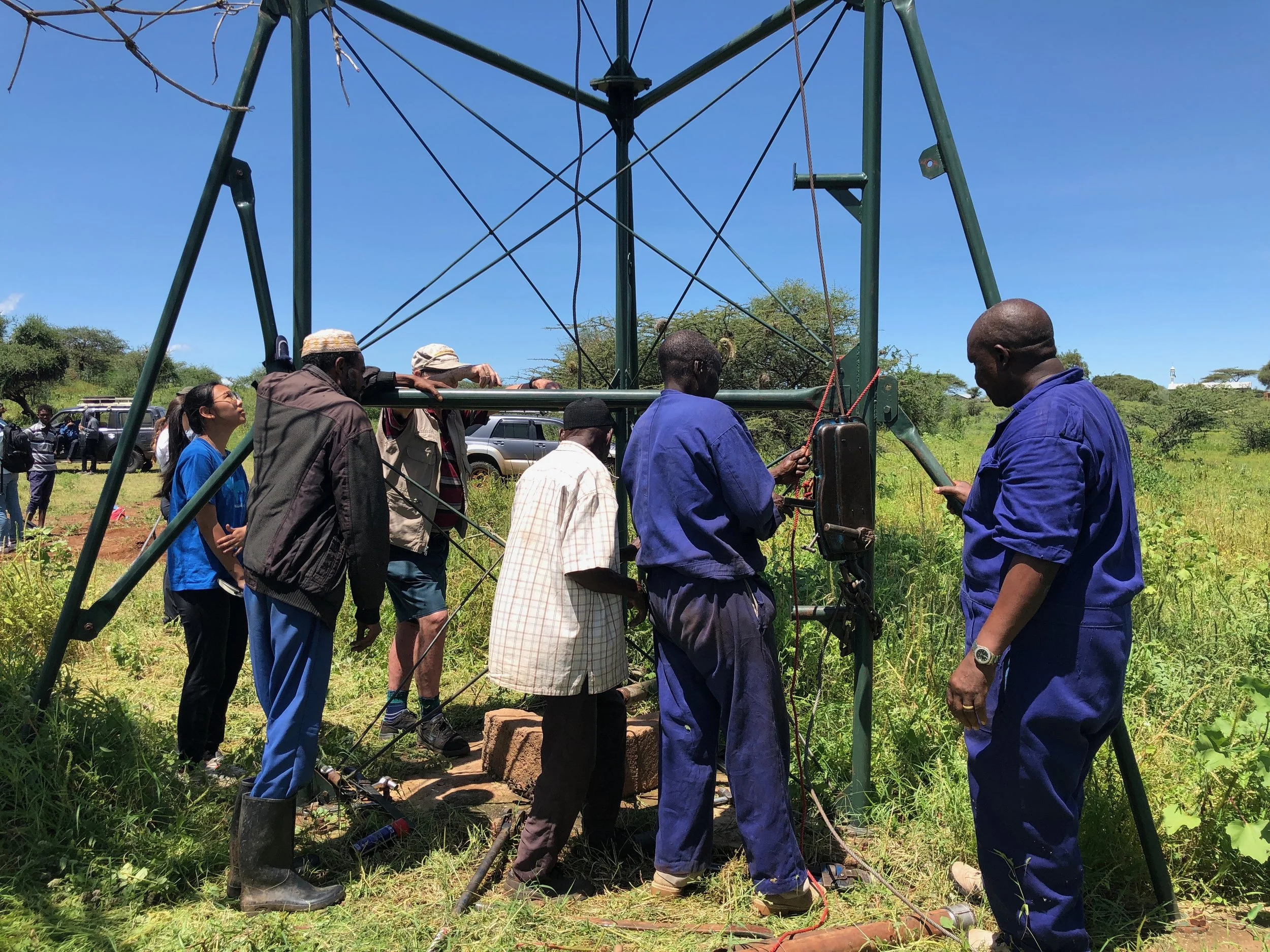 Team members working with village leaders and employees of Kijito Windmill to assess the cause of the broken windmill.