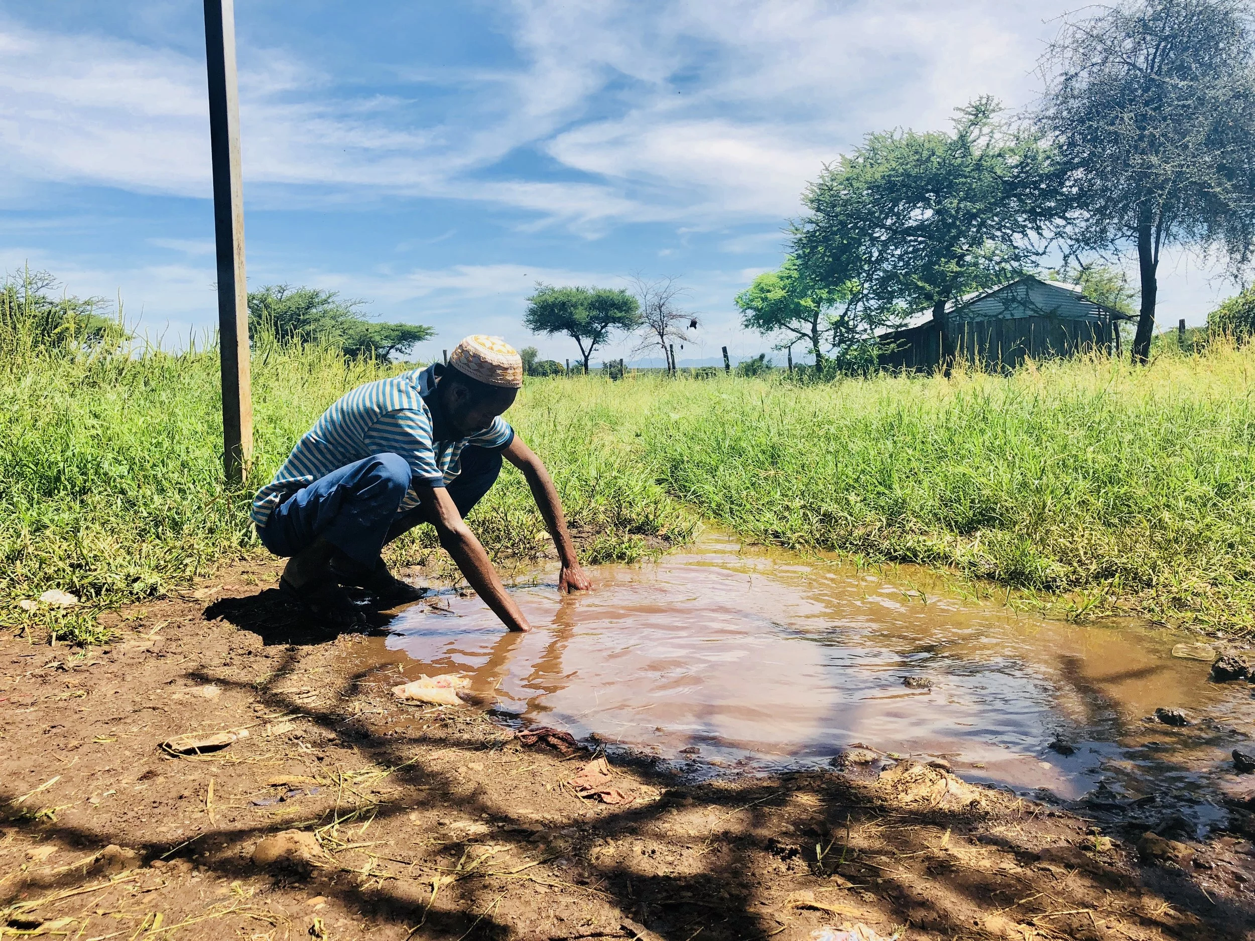 A leader of the Gambella village fetches water from the existing drinking water well.