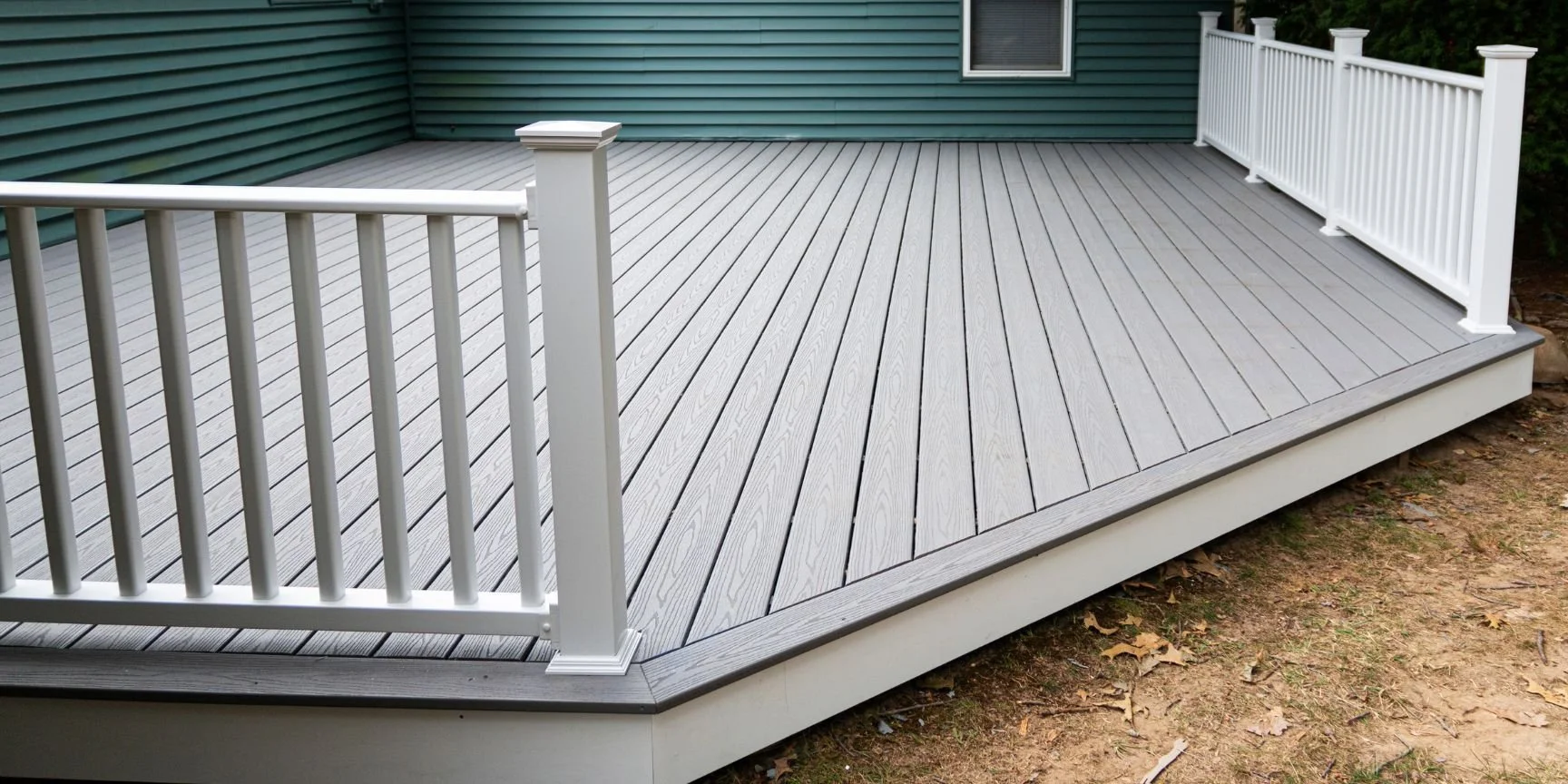 new composite deck on the back of a house with green vinyl