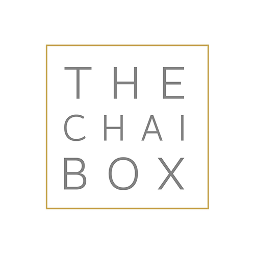 Logo for The Chai Box with gray text inside a gold-bordered square on a white background.