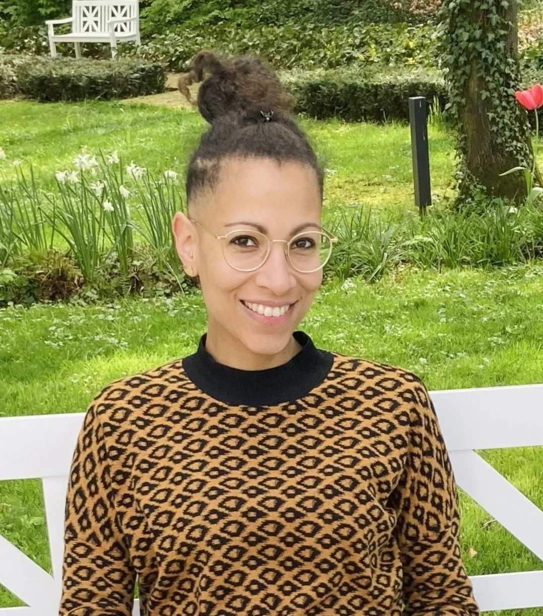 Porträt einer lächelnden Frau mit Brille.