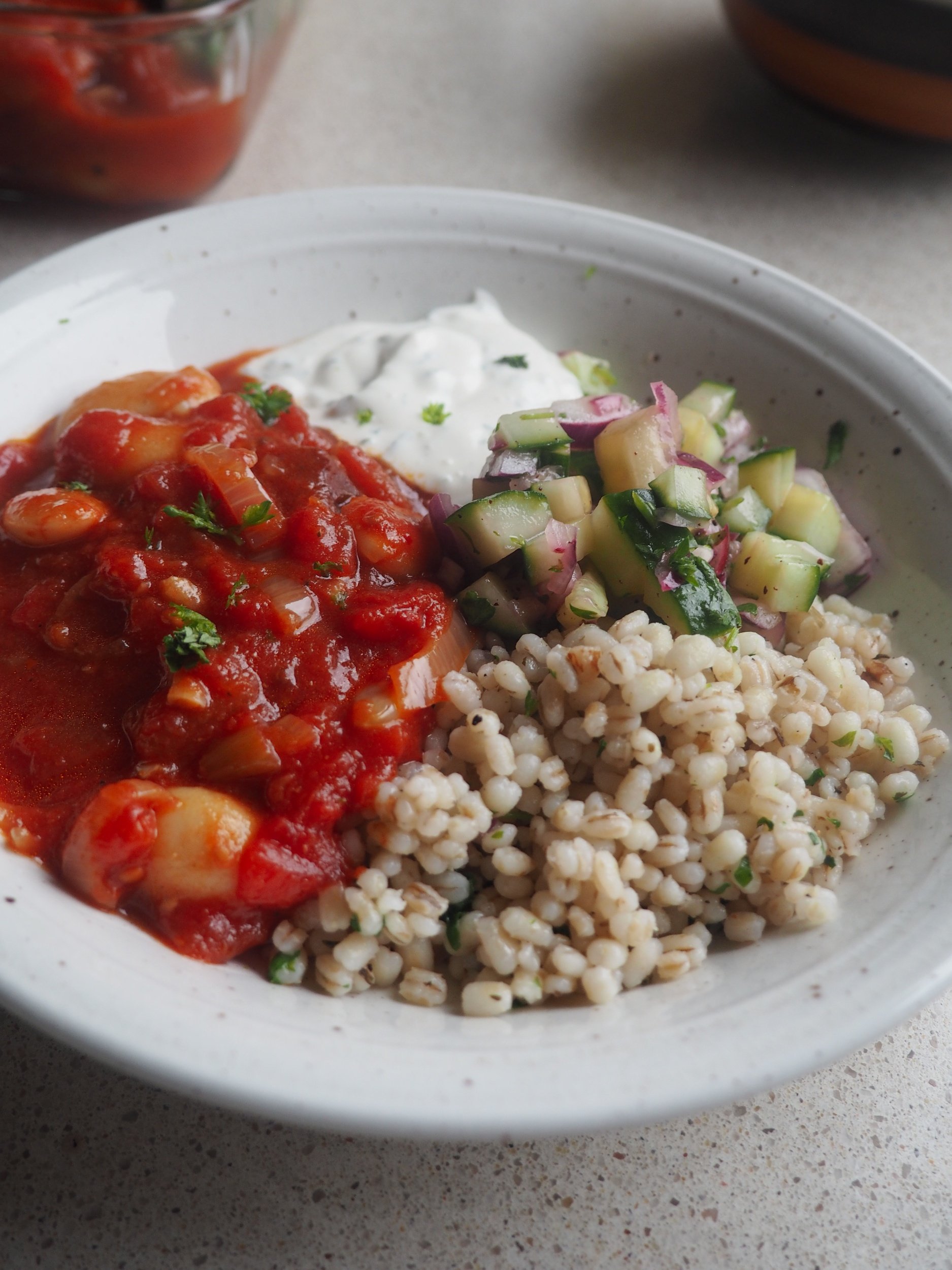 Hvite bønner i tomatsaus med byggryn, agurk, rødløk og yoghurtdressing