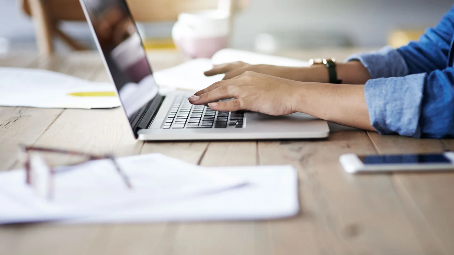 Freiberufler mit Notebook und Unterlagen am Arbeitstisch