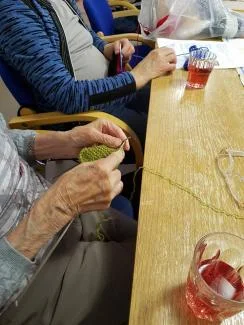 DET STRIKKES: Masfjorden sjukeheim har slått seg på pannebånd og luer.