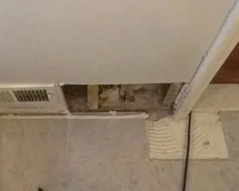 Damaged drywall and tile removed by ServiceMaster during water damage mitigation