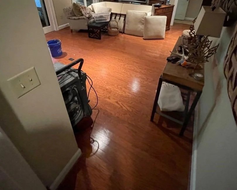 Damaged drywall, flooring and furniture after pipe burst in basement ceiling