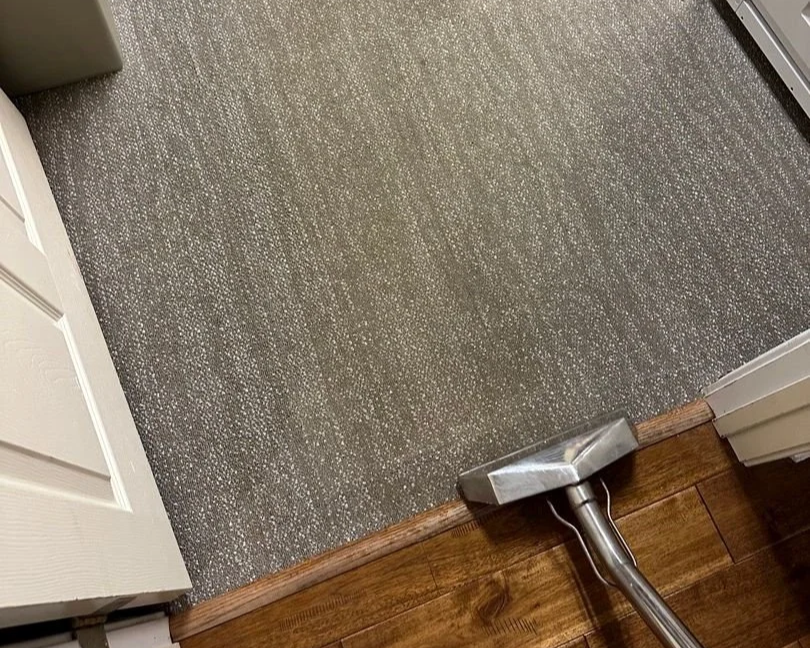 ServiceMaster technician using cleaning wand to clean carpet