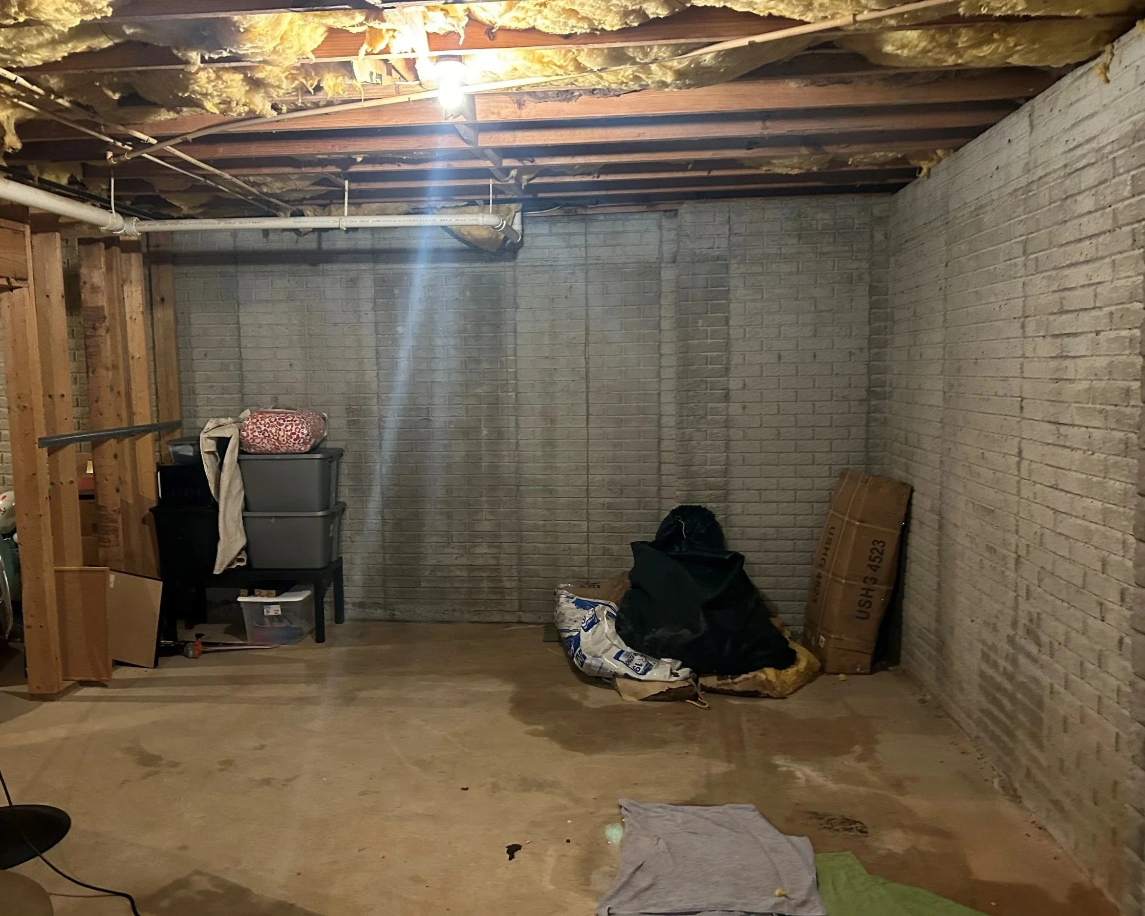 Water running down brick walls and on concrete floor after washing machine overflow