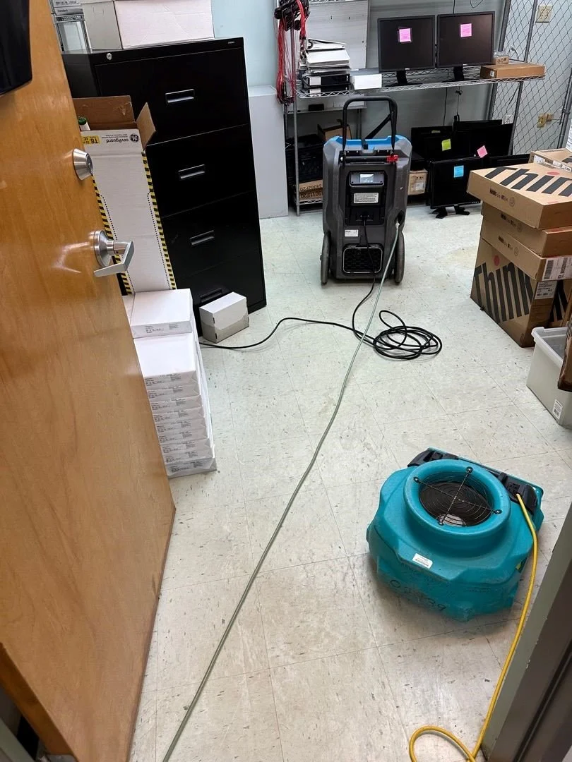 Water extracted from the office floor and equipment set to dry