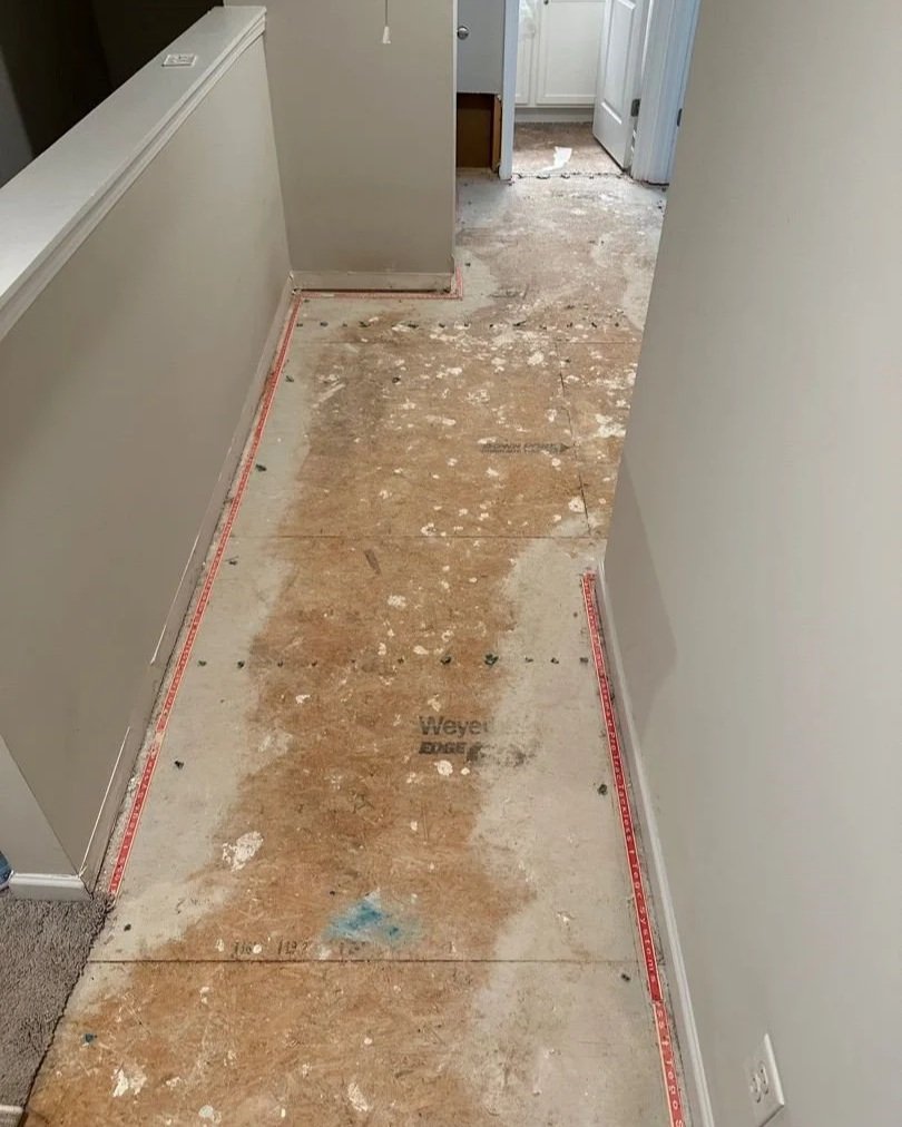 Hallway plywood subfloor after water damaged carpet was removed by ServiceMaster